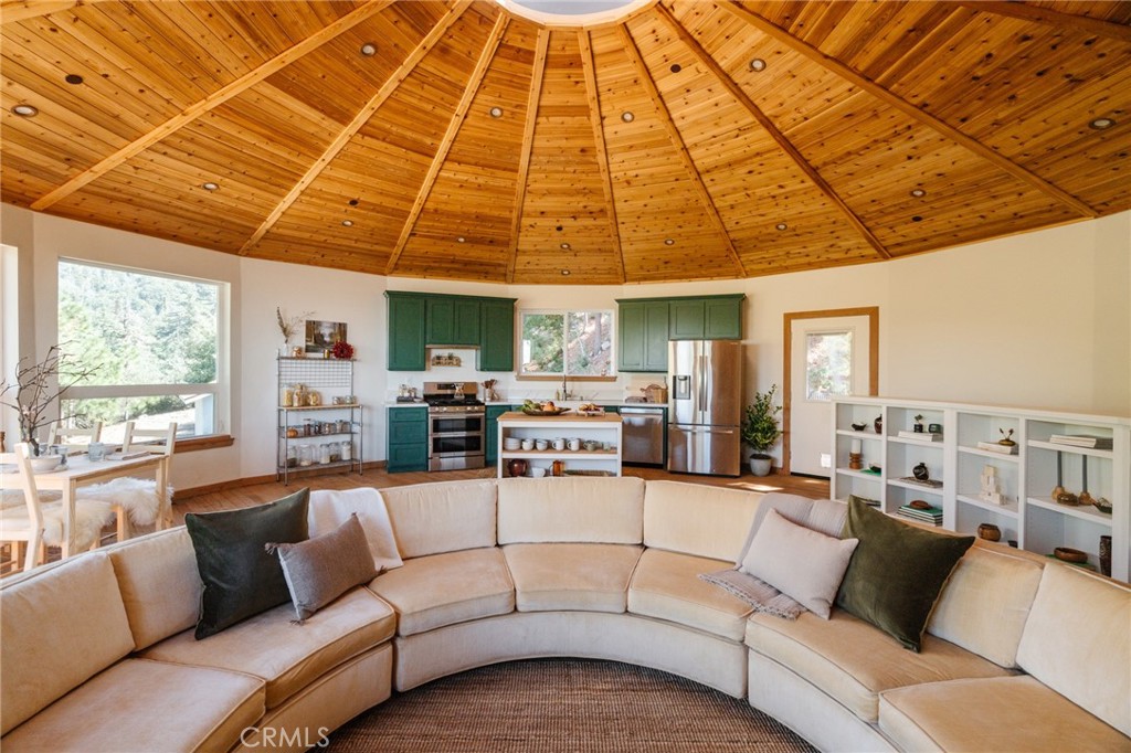 81+ acres of serene privacy in the San Bernardino Mountains! Nested in the trees and just a short distance from the heart of Southern California, this extraordinary Mandala home stands as a testament to innovative design and harmonious living. Thoughtfully crafted in 2019, the design successfully blends the surrounding scenery with airy interiors, featuring panoramic windows, sky lights and an open flowing main living space. A primary suite situated on the main level invites unparalleled natural light and access to an oversized sun deck with expansive views of the property and beyond. An adjacent secondary bedroom makes for a cozy retreat with numerous windows and tree-top sights. Views of Lake Gregory, Mt. Baldy, the Los Angeles skyline and Silverwood Lake can all be experienced from the comfort of home. The ground floor offers flexibility to comfortably host guests in a spacious room with en-suite bath alongside a space to work from home or focus on wellness. Complimenting the home is the expansive property are multiple sites, near or at a distance from the main house, offer opportunities for an array of uses. A hiking trail from the front door leads to the lower and breathtaking section of the property. Here you will find a running creek and light filtering through trees onto large clearings, perfect for gatherings of all sorts. Adjacent to the home is a site for possible guest house with a second septic plan and right out back is the perfect place to stargaze! Home includes AC and a new whole house generator.