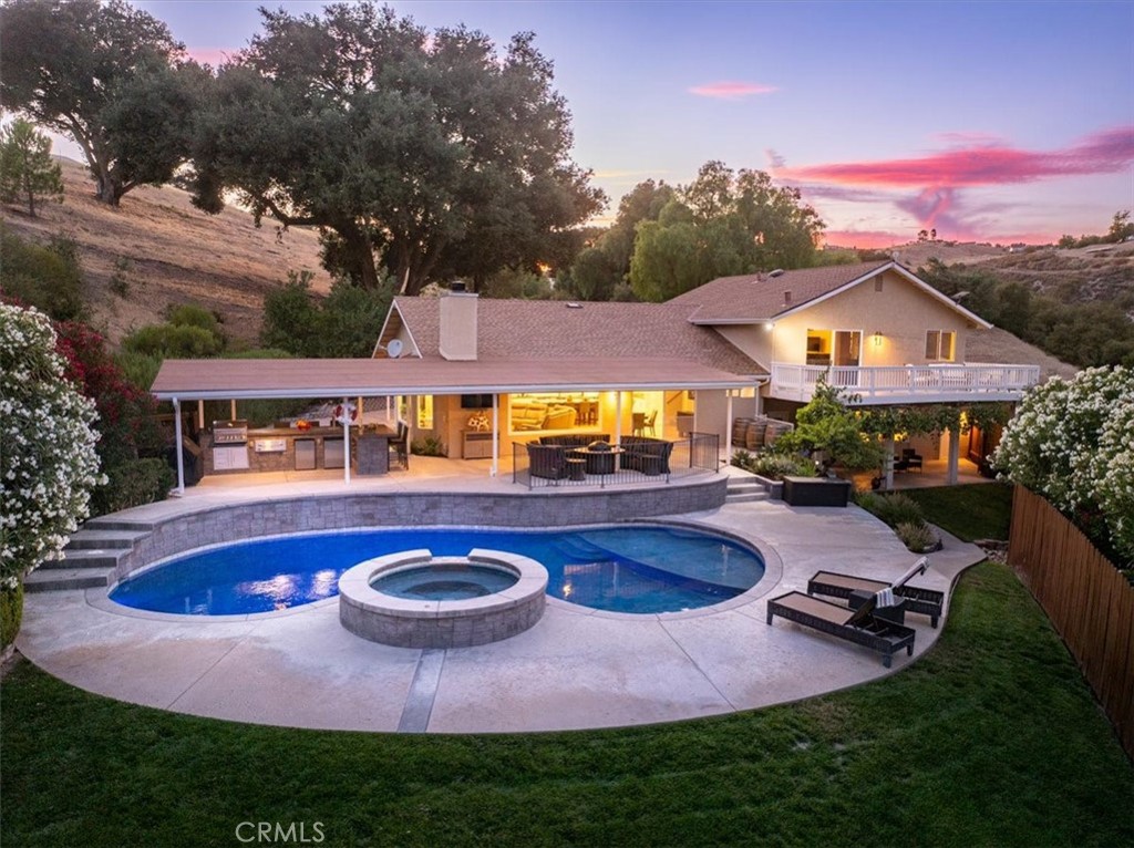 Privately set on five rolling acres in Paso Robles’s coveted Westside, just a few minutes to downtown restaurants and tasting rooms, this custom home with a truly open floorplan, offers the perfect blend of privacy, luxury, and lifestyle. Expansive panoramic views, set the backdrop for resort-style living with a solar-heated swimming pool and spa, and a covered outdoor kitchen equipped with a kegerator, barbecue, sink, and refrigerator for effortless entertaining. Manicured lawns and lush landscaping enhance the grounds, while a magnificent granddad oak tree with a wraparound deck provides a timeless centerpiece. The beautifully remodeled kitchen boasts a Fisher & Paykel 36-inch induction stove with a stunning custom vent, striking counter-to-ceiling stacked tile backsplash, and a waterfall quartzite island with ample seating. Engineered blond hardwood plank flooring by Mohawk and contemporary lighting flow through the home, adding warmth and sophistication. The primary suite features an elegant bathroom with dual sinks, stone counters, soaking tub, and shower, along with a spacious private deck that captures the stunning scenery. A large flex space, currently serving as a game room, can covert to a den or additional living space for family gatherings or any creative use. With owned solar, a privacy gate, four bedrooms, three and a half bathrooms, and plenty of parking including overflow for large gatherings, this property is as functional as it is stylish. Every detail has been thoughtfully considered to create a home that embraces both comfort and the beauty of Paso Robles wine country. Well tested at 22 gallons per minute.