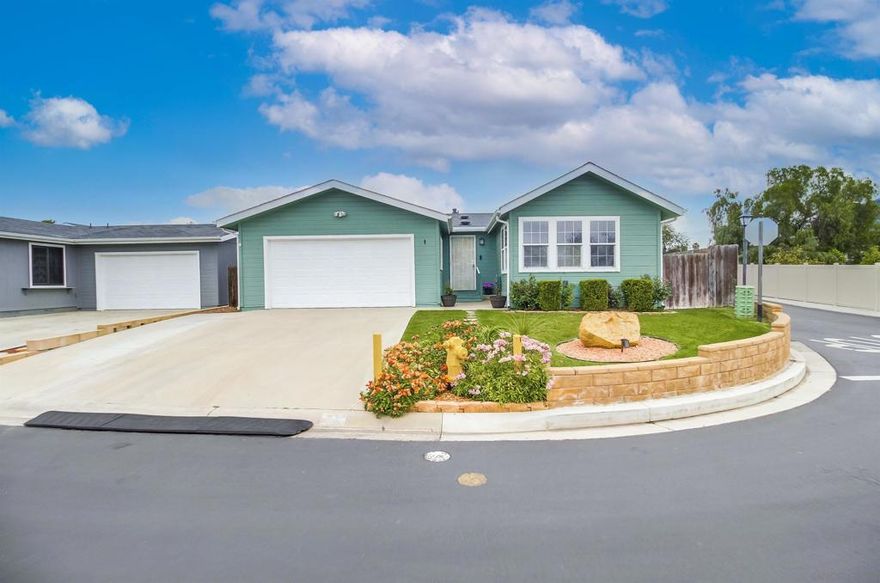 Market time reflects title issue that is now CLEAR!  Ready for quick closing.   Welcome to this charming Woodcreek Estates (all ages park) 3-bedroom, 2-bathroom home located on a corner lot with a permanent foundation. All under vaulted ceilings, enjoy hard surface flooring in the living spaces and primary bedroom and plush carpet in the auxiliary bedrooms, a thoughtfully redesigned kitchen including ample cabinetry, beautiful granite countertops, stainless steel appliances with a double oven and corner breakfast nook.  A walk-in pantry was added for additional storage.  The spacious dining and living room combo bask in natural light.  Both bathrooms have been remodeled with tasteful fixtures.  Additional features include an interior laundry room, enlarged (by 4 feet) garage with storage cabinets, shelving and direct access to the home plus a 3-year new HVAC system + energy efficient ducting.  The spacious backyard is fully fenced and features a large aluminum patio cover with fan/light to enjoy meals al fresco.  The park features ample guest parking, a community room with remodeled kitchen and separate billiard room, pool, spa, gym and RV/Boat storage (extra nominal fee). All appliances, televisions, and tv mounts convey.