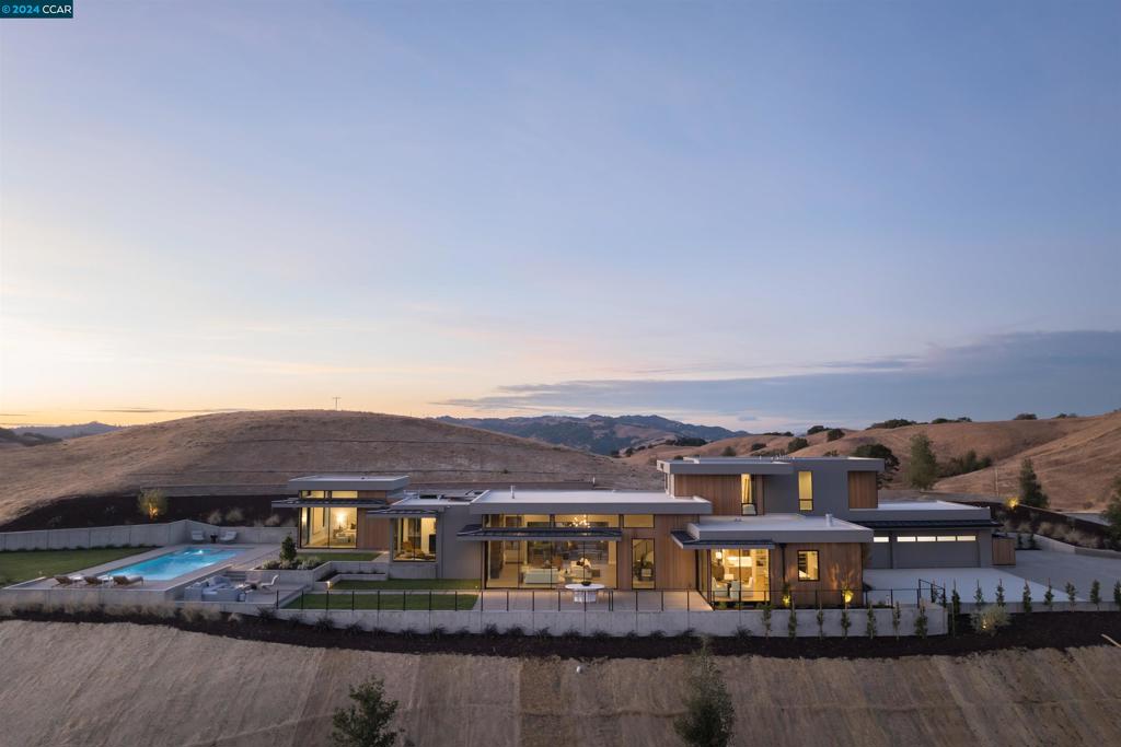 Perched atop a private ascent, this exceptional modern masterpiece is the latest home by Diamond Construction, whose attention to detail, defined by their 1/32" promise is reminiscent of a bygone era. Designed to embrace the ridgeline overlooking the undulating hillside, this home boasts staggering views at every turn. A combination of the highest build quality available, functional biophilic design by renowned Architect, Michael Gale, & planned for long term sustainability it delivers an ethereal experience within its natural surroundings. Seamless custom rift oak flooring, full-height windows & terrestrial material selections by LMK Interiors reflect & engage natural light patterns throughout the day. Revel in an entertainer’s kitchen featuring Lignapal cabinetry, a large island with Calacatta Cremo honed marble, Miele appliances, 8-burner gas range & hidden pantry. Sliding panels in the great room & kitchen glide with ease so you can entertain & enjoy the elevated indoor-outdoor lifestyle. The pool & attached spa, with its oversized Baja shelf, offer the perfect spot for relaxation at any time of day. Primary & office located on the main floor. Secluded, yet minutes from modern conveniences, you’ll be a world away - right at home.