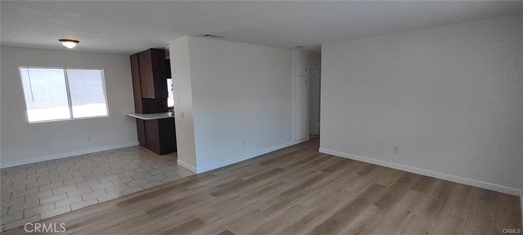 Upstairs unit featuring 2 bedrooms, 1 bath, dining area, large living room, wood laminate flooring, new interior paint, refrigerator and stove included, carport and shared laundry area, water and trash included, covered carport.
