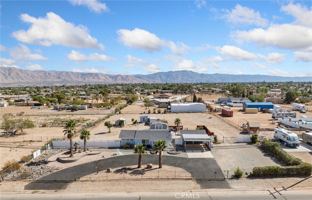 Tucked away in a peaceful Hesperia neighborhood, 17809 Hercules Street blends spacious living with charm and everyday practicality. This well-kept 3-bedroom, 1-bath residence sits on a generous 1.24-acre fully fenced lot — ideal for Horses, RVs, off-road vehicles, gardening, or future expansion. Step into a thoughtfully designed 1,053 sq ft floor plan that feels both welcoming and functional. The living spaces are filled with natural light from updated dual-pane windows, and ceiling fans help maintain year-round comfort. The kitchen stands out with custom wood cabinetry, stainless steel appliances, a 6-burner gas KitchenAid range with hood, and an included refrigerator — perfect for everyday cooking or entertaining. The dining area, complete with a bay window, offers a sunny spot to enjoy your meals. Additional features like hallway storage cabinets add to the home’s smart use of space. In the detached 2-car garage, you’ll find indoor laundry hookups, and the washer and dryer are included. Outside, the property continues to impress with a circular driveway, detached carport, multiple sheds, and a covered back patio that’s ideal for relaxing or hosting guests. Enjoy scenic mountain views and a quiet atmosphere — all while being just minutes from Main Street, I-15 Freeway access, and close to schools, restaurants, and shopping. Whether you're seeking extra space for hobbies, equipment, or future plans, this high-desert gem offers room to live and grow. Don’t miss the opportunity to make it yours.