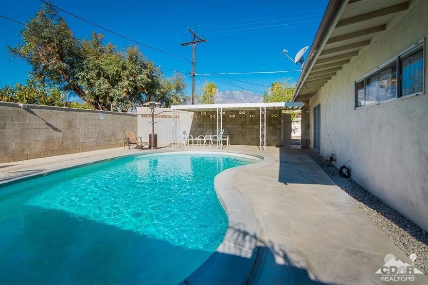 Lowest priced Pool home in Panorama! Mid century charmer located in popular Panorama area. Lot feels much larger than tax records indicate! Great south and western mountain views from side patio and rear pool area. Nicely updated inside with new kitchen cabinets and oak butcher block counters with stainless appliances. Spacious living/dining area with glass door access to west patio and slider access to separate pool area in rear.3 Bedroom/2 Bath including master suite. Freshly painted, tile floors in main living areas and ceiling fans throughout. South facing saltwater pool with southern mountain views and covered patio. If you have a home business, love to tinker in the shop or vehicles are your hobby, you will love the oversize, deep, double car detached garage complete with air hookups! Gated driveway access, extra parking on lot including room for an RV. Separate pad and large shed for extra storage and toys.