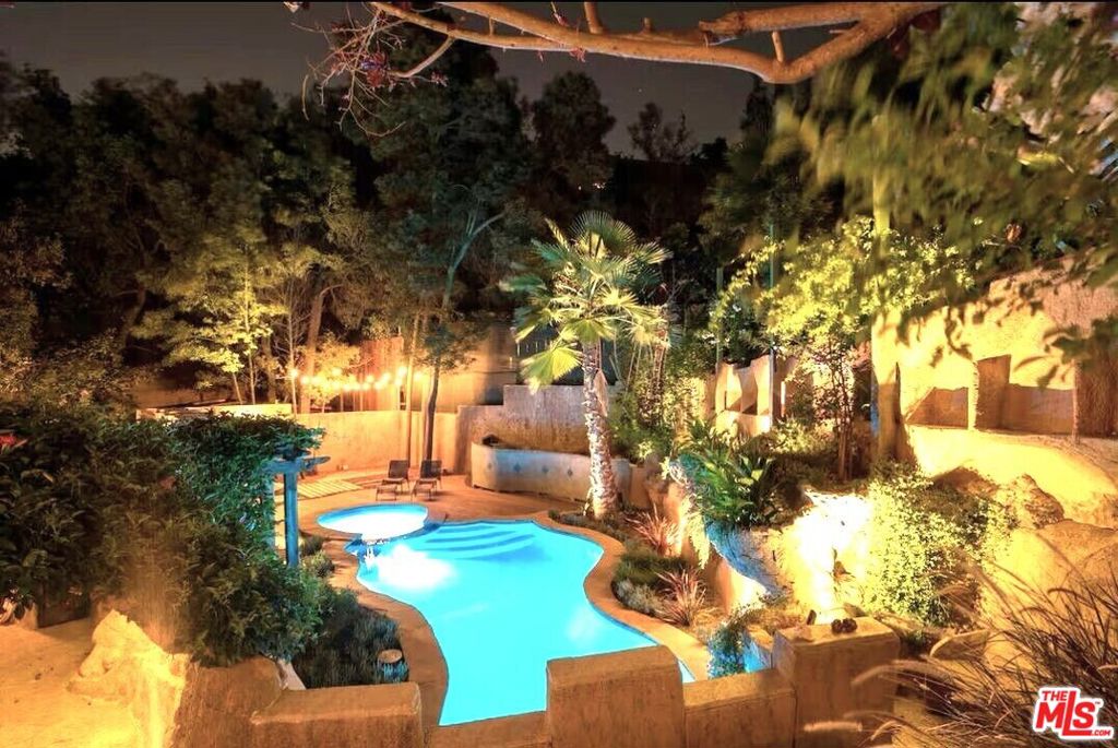 Historic Laurel Canyon: This extraordinary Hollywood Hills estate, the renowned Wonderland Castle, was designed in 1931 by a legendary set designer. The 3bd/2ba gated and private residence is truly a work of art with exceptional celebrity provenance. Every room features unique details, including vaulted or Monticello ceilings, bespoke cathedral doors, polished hardwood floors, turrets with secret conversation areas, and an abundance of artistic windows that flood the space with sunlight. Completely remodeled in 2014, this stunning residence offers cooking enthusiasts a chef's kitchen with breakfast bar/island, top-end appliances, laundry area, hand-hewn built-ins, and a cozy breakfast cove with a stunning live-edge table and corner banquette. Off the breakfast nook, huge doors lead to a captivating balcony that overlooks the free-form saltwater pool area edged with vividly colored florals and featuring a stone tunnel, footbridge, waterfall, and bubbling spa. A semi-circular step/up primary bedroom wing with towering ceilings is its own exclusive retreat. It features a fireplace, a dressing area with a modern clawfoot tub, and access to a secluded and very romantic garden courtyard with antique gates and a soothing fountain. An artisan-crafted stone fireplace is the focal point of the sunken living room, which incorporates two offset spires designed as conversation areas, spectacular windows that capture the breadth of the lush estate, and a circular stone stairway that leads to the lower-level bedroom wing. The guest bedroom is highlighted by a fireplace, wine cove, and its own private entrance that opens onto the spectacular grounds. Each of the home's stunning bathrooms offers luxurious Carrera marble showers designed for ultimate pampering with multiple shower heads, high-end fixtures, unique windows, and top-tier Japanese bidet toilets. Start each day with morning coffee on one of the many private patios, each surrounded by greenery and walls of stone created by the talented designers of this timeless work of art. At the end of the day, residents and their guests will look forward to strolling along the winding, verdant pathways or relaxing with a glass of wine around a fire pit in one of the several outdoor conversation areas nestled among the oak trees. Inside the secure quarter-acre property, there is space for six cars. Studio-close and minutes from the Sunset Strip, West Hollywood, the iconic Laurel Canyon Country Store, Mulholland Drive, and Studio City's trendy shops and bistros, the location offers hiking trails, lookout points, and ultimate convenience. Laurel Canyon, known for its rock 'n' roll history, is also the home of the highly desirable Wonderland Elementary School District. Note: Beautifully furnished, but most pieces can be stored to accommodate tenant furniture if requested. Please call regarding pets or to schedule a private showing. *Due to the era in which the home was built, records are not up-to-date re square footage, which is greater than shown on Title. Professional measurements are currently scheduled.)