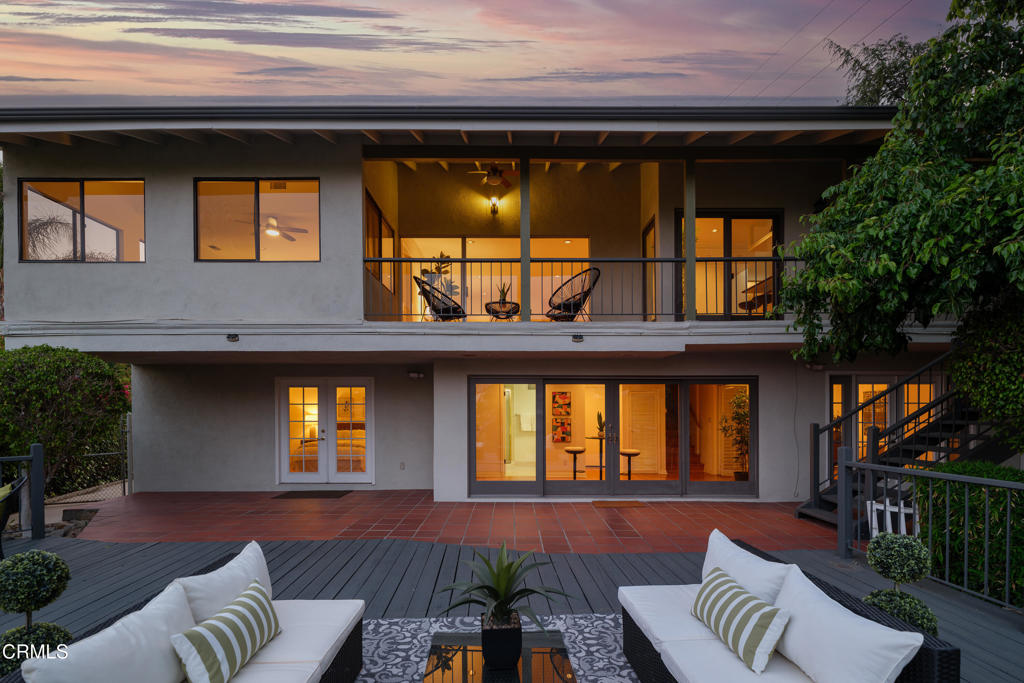 Set against serene canyon views in the hills of La Canada, this classic mid-century residence offers an exceptional opportunity for multigenerational living with over 3,200 sq ft of versatile space, two full kitchens, and two laundry areas. A double-door entry welcomes you past vibrant landscaping and a stately staircase. Inside, gleaming hardwood floors, recessed lighting, and timeless architectural details create a warm and elegant atmosphere. The main level features a spacious living room with a statement fireplace and sliding doors that lead to a covered balcony with sweeping views--perfect for relaxing or entertaining. The formal dining room, framed by a large picture window, flows into a well-appointed kitchen with granite countertops, abundant cabinetry, a 5-burner electric cooktop, double oven, and dishwasher. Nearby, a laundry closet with hookups, a cozy office nook, and side yard access provide everyday functionality. Three generously sized bedrooms are also found on this level, including a suite with a jetted spa tub, dual-sink vanity, and tiled shower. Another bedroom enjoys panoramic views through wraparound windows, while the third is adjacent to a full hallway bath with stone counters and a tub/shower combo. The lower level offers true multigenerational potential with a fully self-contained suite. This private space includes open-concept living and dining area, full kitchen with granite countertops and 5-burner gas range, 3/4 bath, its own laundry hookups, and a bedroom with dual closets and French doors opening to a private patio and deck. Terraced outdoor spaces offer multiple zones for gardening, play, or quiet reflection--whether lounging by the fire pit, enjoying the hammock, or reimagining the lower yard as garden beds or recreational space. Additional highlights include an attached 3-car garage with EV charging, ceiling fans, and thoughtful updates throughout. This home offers the perfect blend of shared and private spaces--an ideal layout for extended family, guests, or rental income--all while enjoying the beauty of indoor-outdoor California living.