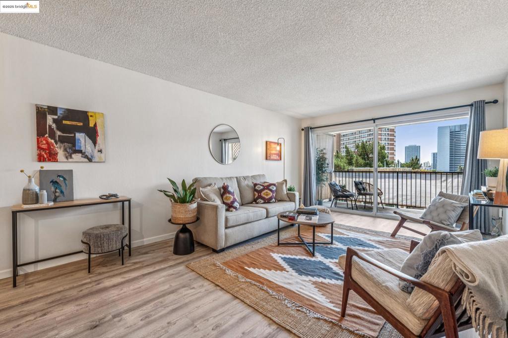 Light and bright top floor unit with unparalleled convenience in Adams Point! As you enter, you are greeted by an open-concept living space filled with natural light streaming through the dual-pane sliding glass door. The living room flows seamlessly into the dining area and a sleek, upgraded kitchen boasting stainless steel appliances. The thoughtful layout ensures every inch of space is utilized efficiently, providing a cozy yet functional environment for modern living. The spacious primary bedroom is a comforting safe haven, featuring a dual-pane window, generous walk-in closet, and an ensuite bathroom. This perfect package would not be complete without the convenience of in-unit laundry, making everyday tasks a total breeze. The building itself is solar-powered, helping to offset energy costs and reflecting a commitment to sustainability. Secure underground parking, two accessible elevators, and intercom access add to the package of amenities designed for your peace of mind. Just minutes from Lake Merritt, this location provides easy access to shopping, dining, and transportation options like BART and major freeways. Experience the exceptional blend of comfort, style, and community that awaits you at 85 Vernon St #305. Your new chapter starts here—come see it today!