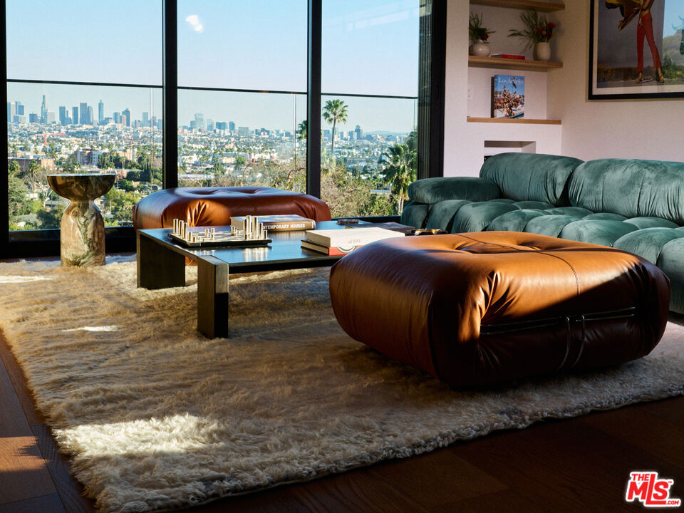 Tucked away in the exclusive Hollywood Hills, this private retreat seamlessly blends Old Hollywood glamour with modern luxury. Just minutes from the iconic Hollywood Sign, top studios, and world-class dining, it offers the perfect balance of seclusion and convenience. Designed with exquisite craftsmanship, the home showcases top-of-the-line finishes, including Brazilian woodwork, Italian marble, and bespoke wood cladding, plus a smart home system, creating an atmosphere of timeless sophistication. Expansive windows flood the space with natural light while framing breathtaking views. The main house features two bedrooms and 2.5 baths, while a detached bonus room serves as a versatile third space with its own bath, ideal for guests or a creative studio. Outside, the beautifully designed oasis invites effortless entertaining with a sparkling salt water heated pool, spa, fire pit, built in BBQ area, 2 car garage, all set against the backdrop of the serene Hollywood Hills. A true masterpiece, where classic elegance meets contemporary tranquility.