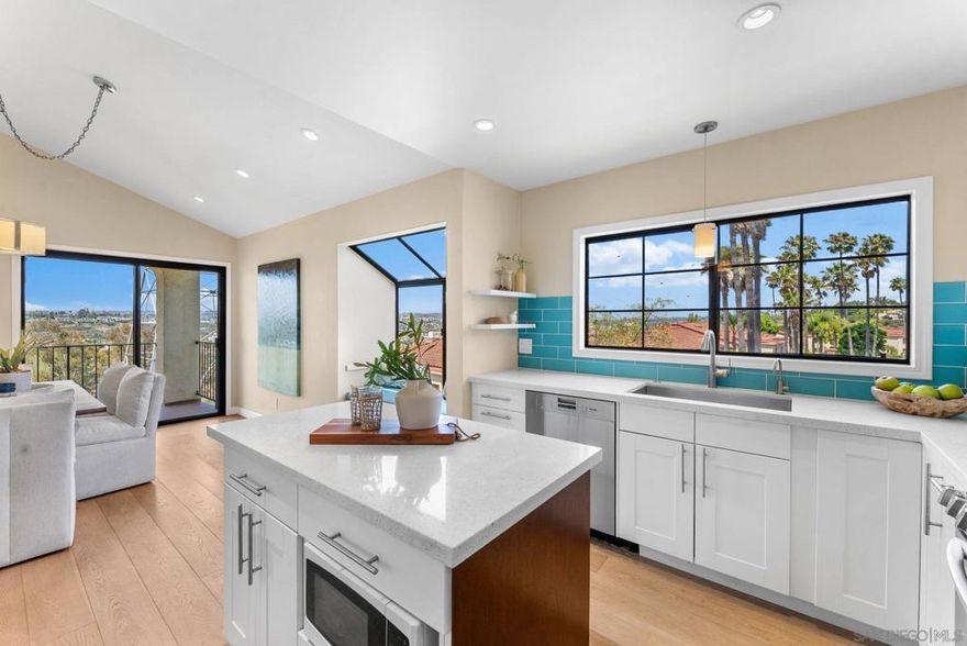 Experience coastal living at its finest in this immaculate, top-floor corner residence offering panoramic views stretching all the way to the Pacific. Flooded with natural light, this 3-bedroom, 2-bath home combines modern design with relaxed elegance.  The open-concept living area showcases vaulted ceilings, wide-plank white oak flooring, and seamless flow between the living, dining, and kitchen spaces. The custom kitchen stands out with white shaker cabinetry, quartz countertops, and premium stainless steel appliances — the perfect setting for entertaining or enjoying everyday meals with a view.  The spacious primary suite is a private retreat, featuring two walk-in closets and a spa-inspired bathroom with designer tile, dual vanities, and a luxurious walk-in shower. Two additional bedrooms offer flexibility for guests or a home office, complemented by an equally stylish secondary bath.  Additional features include in-unit laundry hookups, a private one-car garage plus an assigned parking space, and thoughtful upgrades throughout.  Located within the sought-after Sea Point Tennis Club, residents enjoy access to tennis courts, multiple pools and spas, and beautifully maintained grounds. All just minutes from La Costa’s best shopping, dining, golf, hiking trails, and beaches.