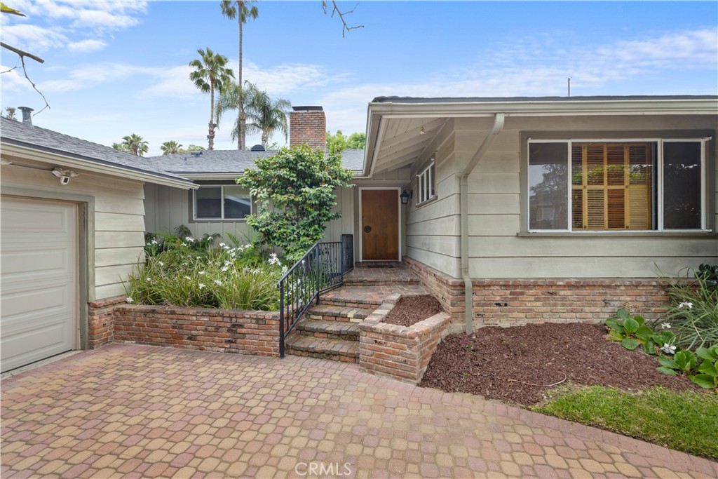 We are delighted to present this charming and spacious traditional residence, ideally situated on a serene cul-de-sac south of the boulevard in the heart of Studio City. Nestled in a coveted neighborhood, this three-bedroom, two-and-a-half-bathroom home gracefully blends original character with thoughtful updates. This home has been lovingly cared for by the seller for the past 50 years and they were only the second owner. The new roof was installed in 2022 alleviating any concern for roof maintenance.
As you arrive at the home, you will notice the abundantly producing orange tree and the curved driveway leading to the two car garage with direct
access to the home. Upon entry, a formal foyer welcomes you into a generously proportioned living room, complete with a classic brick fireplace and an adjoining dining area—perfect for both casual and formal entertaining. The very sizeable updated kitchen is a chef’s delight, offering abundant counter space, modern appliances, and a large skylight that bathes the room in natural light. An expansive counter with seating provides a casual dining option, while the adjacent oversized laundry room and conveniently located powder room enhance functionality.
Accessible from the kitchen is the attached two-car garage, adding ease and practicality. Just off the main living area is a warm and inviting wood-paneled den, featuring a built-in wet bar, ideal for hosting guests. Both the den and living room open to an enclosed patio, creating a seamless indoor-outdoor flow for al fresco dining or relaxing evenings.
The home’s private wing hosts all three bedrooms. The spacious primary suite offers a peaceful retreat with a dedicated vanity area, ample closet space, and direct access to the backyard. Two additional well-sized bedrooms share a full hall bathroom and boast large closets.
Step outside to a beautifully landscaped backyard featuring a grassy area, a relaxing spa, and direct access to the pool area via a short flight of steps. The fully fenced pool is surrounded by mature landscaping, offering both privacy and a stunning setting for outdoor entertaining.
This timeless residence combines comfort, character, and classic California living—all in one of Studio City’s most desirable enclaves.