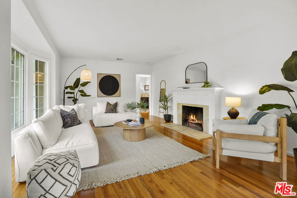 Framed by mature fruit trees and a soft stucco exterior, this well-maintained 1940s traditional jewel opens to bright, well-proportioned rooms featuring gleaming wood floors and an abundance of natural light. The large living room centers on a decorative fireplace and a wide bay window overlooking the front garden, with original trim and a classic plaster mantel that reflect the home's 1940s craftsmanship. The dining area sits just beyond, open yet defined, with large windows that bring in afternoon light. Its generous size allows room for a full table and additional serving space, creating a comfortable setting for gatherings. The large kitchen has been updated and features granite counters, tile flooring, a double oven, and ample cabinetry surrounding a central island that adds both workspace and casual seating. The layout encourages a natural flow between cooking, dining, and conversation. The three bedrooms include a spacious primary suite with built-in storage, a decorative fireplace, and space for a sitting area. The private bath with double sinks, framed mirrors, a make-up station, and a tiled shower accented by brass fixtures, a nod to the home's original character. A second bedroom also enjoys an en-suite bath, while the third bedroom is served by a hall bath that has been updated with modern finishes and fixtures. The home spans over 1,600 square feet on a 5,500-square-foot lot. A long driveway provides generous parking with room for an RV and leads to a private backyard with a patio and mature fruit trees - tangerine, peach, citrus, fig and pomegranate among them. Fresh interior and exterior paint, solar panels, and an upgraded 200A electrical panel add everyday reliability, this beauty is move-in ready. The result is a home that feels both rooted and refreshed, reflecting years of care and a clear respect for its original character. Located at the border of Sunland & Tujunga, nature is never far away: explore the Haines Canyon Park, La Tuna Canyon, Oro Vista Park, or any of the many other trails, golf courses, and recreation areas. If you're ready for open air, lots of trails, and community engagement, this home is ready for you.