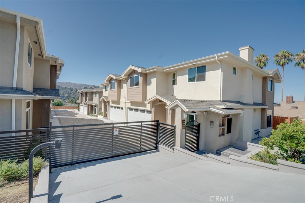 Welcome to this beautifully designed townhouse in the heart of Tujunga, offering modern luxury and thoughtful details throughout. This home features high ceilings, stunning SPC wood-like tile flooring, quartz countertops, and a stylish color-changing gas fireplace. The open floor plan flows seamlessly from the living area to the dining space, where sliding doors lead to a spacious private patio—perfect for indoor-outdoor living.
The modern kitchen boasts a large breakfast area, stainless steel farmhouse sink, high-end white cabinetry, and premium appliances. Additional highlights include built-in displays and cabinets, central air and heat, a convenient laundry chute, an adjacent half bath, and a large laundry room with a sink.
Upstairs, you'll find two ensuite bedrooms with generous closet space, offering comfort and privacy.
The community provides five guest parking spaces, a cobblestone paver driveway, and a shared BBQ/picnic area. Conveniently located with easy access to freeways and shopping, this townhouse combines luxury living with everyday convenience.