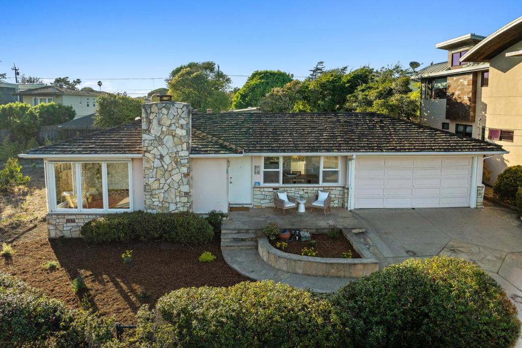 Legend has it, there's a pot of gold at the end of the rainbow. It just so happens, that there is a pot of gold at the end of 15th in SC. With unobstructed views of Blacks Beach, the 3 bed. 2 bath home is what coastal living is all about. Long time residents have been enjoying this custom built home & built in 1956. When you walk in the front door, that ocean view is Wow! Views from the living room with a beautiful fireplace with pink granite surround. Dining room has ocean views too, an adjoining kitchen with backyard views and 3 spacious bedrooms are comfy! The primary bedroom has an en-suite bathroom & plenty of closet space & natural light from the many windows. 2 more bed. are also roomy & a 2nd bath. There is a slider in the back bedroom to a beautiful brick patio. There are beautiful hardwood floors throughout, solid surface countertops in the kitchen, tiled bathroom floors & tiled counters. An added bonus is the cute cottage with its own bathroom & access to the large backyard. There is a 2 car garage with cabinets for tools & a workbench. More parking in the driveway. Freshly painted inside, landscaped & ready for the new owners to enjoy. Don't miss out on this opportunity to purchase a little piece of heaven at the end of the rainbow.