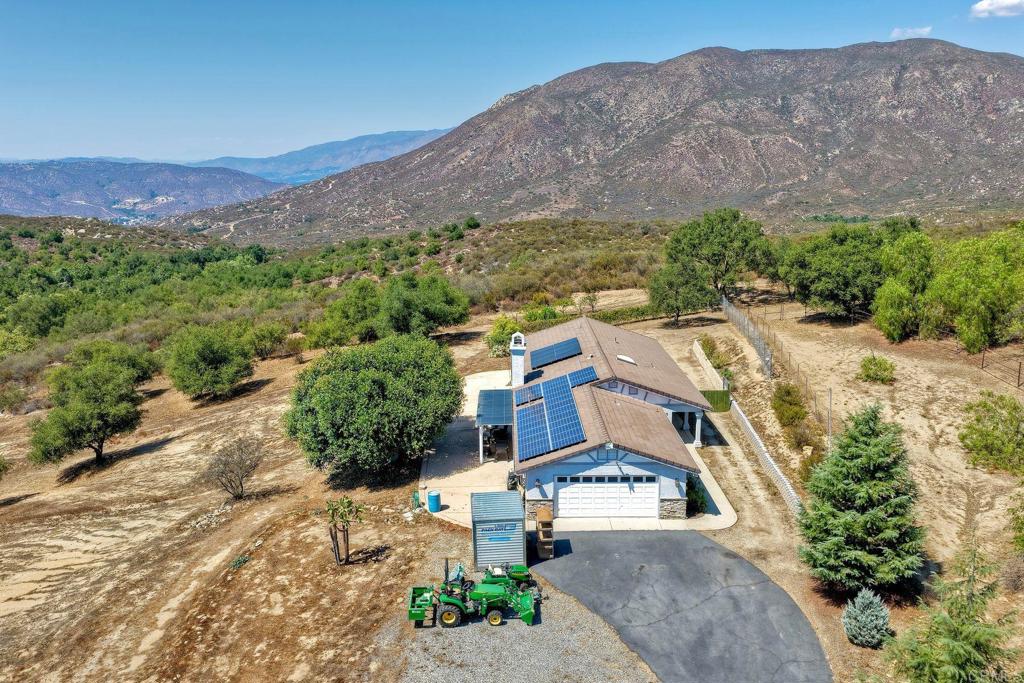 Nestled at the end of a peaceful cul-de-sac, this tranquil, single-story retreat offers ultimate privacy behind an elegant iron gate and a long, paved driveway with ample parking. The home features a beautiful stucco exterior, tile roof with solar panels and Tesla PowerWall batteries, and a private patio with breathtaking canyon and mountain views, including Hellhole Canyon County Preserve. Set on 4.53 acres, enjoy stunning vistas, established gardens with raised beds, and abundant flat spaces for additions like an ADU, JADU, horse stalls, or gardens, making self-sufficient living a real possibility. Experience serene nature and limitless potential in this exceptional property.