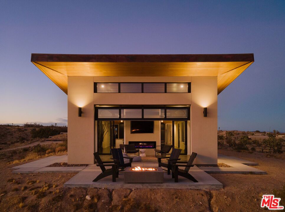 Perched on a serene hilltop with sweeping 360-degree views of the high desert, The Foundry is a rare opportunity - ideal as a refined second home or an inspired retreat. Created by renowned local developer Building Joshua Tree, this newly built residence merges timeless mid-century architecture with the raw elegance of its natural surroundings. Expansive glass walls bathe the interiors in natural light, while soaring ceilings enhance the open, airy ambiance. The chef's kitchen features top-of-the-line Cafe appliances, and two peaceful bedrooms provide a calming refuge. The bathrooms are thoughtfully designed to balance clean aesthetics with everyday functionality. A sunroom with three retractable glass walls anchors the seamless indoor-outdoor living experience, opening the home to the tranquil desert landscape. Wellness amenities including a red cedar hot tub, barrel sauna, and cold plunge invite deep relaxation and connection to the restorative energy of the environment. Consistently ranked in the top 5% of Airbnbs in Joshua Tree, this home stands out with an exceptional occupancy rate and even more impressive gross income - offering strong appeal for future investors. The current owner is also open to continued management, making this a truly effortless and high-performing investment. The Foundry is more than a home - it's an immersive desert experience that blends architectural sophistication with natural beauty, offering a lifestyle of peace, privacy, and purposeful living.