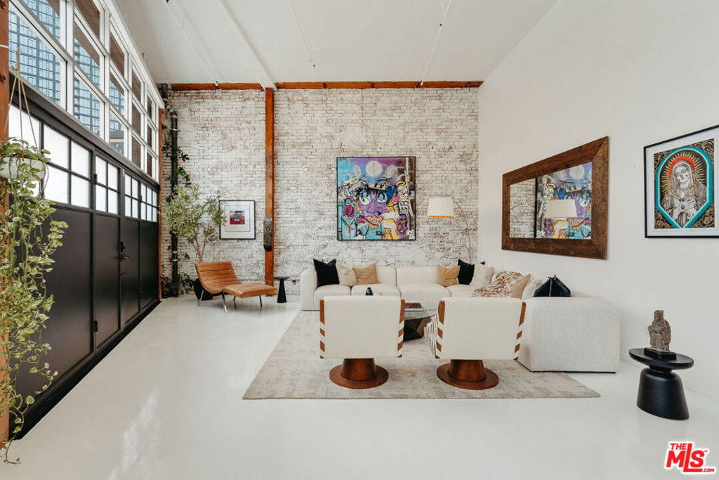 A rare opportunity to own a truly distinctive live/work loft in the heart of the Arts District - a space that perfectly blends creativity, comfort, and design. Originally renovated by a renowned film and television composer, this residence features a fully operational, soundproof recording studio built to professional standards ideal for music, film, or post-production work. Every element was crafted with precision and no expense spared, resulting in a space that's as functional as it is inspiring. Beyond the studio, the home offers a warm, livable layout anchored by a spacious master bedroom suite with built-in upper storage and the flexibility to be converted into a second studio if desired. The custom-built galley kitchen combines thoughtful design with quality finishes, making both everyday living and entertaining effortless. Additional highlights include 15.5-foot ceilings, original brick, post and beam accents, custom soundproofed steel entry doors and windows, power shades, and newly refinished white epoxy floors that lend a sleek, gallery-like atmosphere. A private street-level entrance with dedicated parking enhances both privacy and convenience. Set within the iconic Molino Street Lofts, a hallmark of 1920s warehouse architecture converted into 91 condominiums in 2006, residents enjoy two rooftop decks with city, building, and street views, a pool and BBQ area, and a fitness center. Surrounded by the creative pulse of the Arts District just steps from Hauser & Wirth, Manuela, Bavel, Verve Coffee, ROW DTLA, Soho House, local mural tours, Hank's Organic, the Arts District Dog Park, Damian, Bestia, Girl & the Goat, Urth Caffe, and more this vibrant neighborhood is also home to innovative companies such as Honey, BMG Music, 3sixteen, Soylent, Lucky Brand Jeans, and Spotify. This is an exceptional opportunity to own a true creative sanctuary and refined urban home.