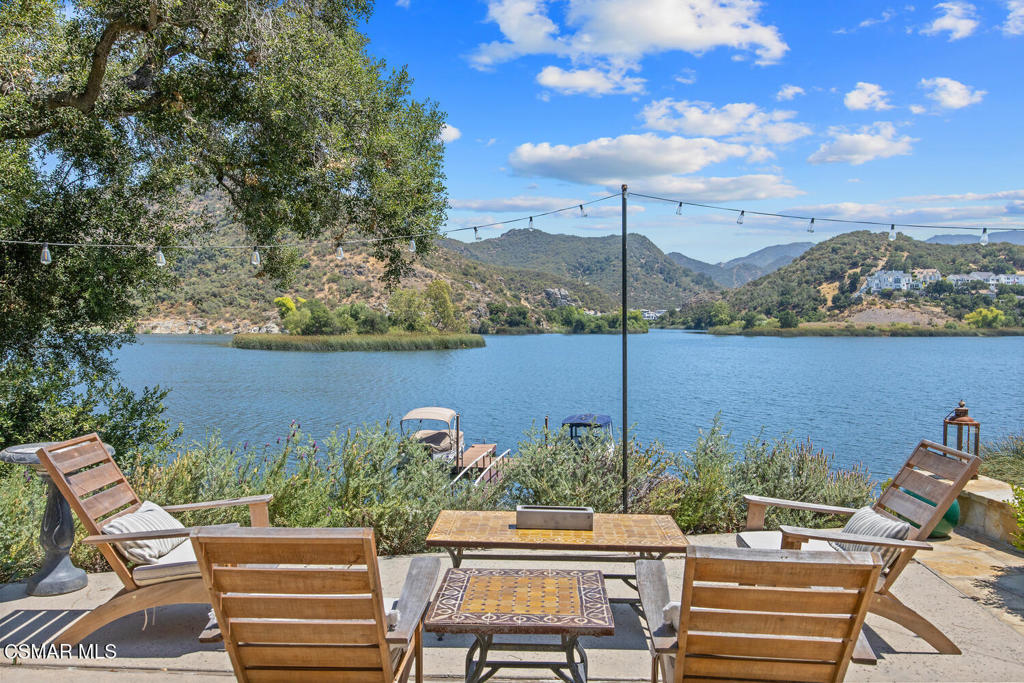 Experience vacation living every single day living at this lakefront home in prestigious Lake Sherwood. A home in this highly sought after location is rarely on the market, and this waterfront locale is arguably THE BEST SPOT on all of Lake Sherwood. Sitting out on the back patio watching the birds and the boats go by is the most relaxing experience and this view is a panoramic lake view right in the middle of the lake. You can see the water shimmering on the lake from almost all the rooms in the home and since the back of the home faces West, the angle of the sun at this home is ideal. At sunset, take a soak in the gorgeous stone infinity spa and life is darn good. This home comes with a private boat dock located right in front. The property features private oak trees and rose and lavender gardens that extend from the patio to the water. With three bedrooms and a spacious office, and two full bathrooms plus a powder bathroom, this ONE STORY home is a wonderful retreat. Bulit in 1954, much of this home has been updated, but it has retained it's vintage charm. The primary bedroom is enormous with a large walk-in closet and floor to ceiling windows to enjoy the lake view at any time of day. The kitchen is a gallery style kitchen with a new induction stove, and the large walk-in pantry will delight all family members. There is also an indoor laundry room with a sink. One perk of this location is access to the private walkway in front of the lake front homes on the north side of the lake which is a magical place to take a morning walk. There is also a converted boat house for extra storage. Please note there is a carport for two cars and ample parking on the driveway but no garage.