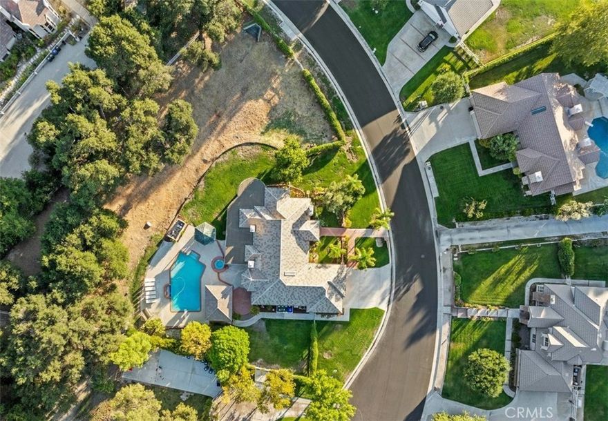 Stunning single-story home on a quiet cul-de-sac in the sought-after Crystal Springs Ranch area of Sand Canyon. Set on nearly an acre, this private estate blends elegance with resort-style living. Inside, you’ll find 3 bedrooms plus a den/office that can easily serve as a 4th bedroom, 3 full baths, and thoughtful spaces throughout. The gourmet kitchen features stainless steel appliances, double ovens, a large island, hammered copper sink, bronze fixtures, and a charming breakfast alcove with custom cabinetry. Between two of the secondary bedrooms is a versatile flex space, perfect for study, play, or a lounge area, and these bedrooms share a Jack and Jill bathroom. The optional 4th bedroom is also connected to a bathroom, adding functionality for guests or multi-generational living. The interiors include soaring ceilings, wood floors, French doors, and three fireplaces, with a primary suite retreat showcasing a spa-like bath with custom cabinetry, elegant vanities, a handcrafted hammered copper soaking tub, glass block walls, and a hidden walk-in closet. Outdoors, the property transforms into an entertainer’s paradise with a sparkling pool and spa, a full outdoor kitchen and barbecue area, gazebo, and a covered patio that spans nearly the length of the home. With its three-car garage, indoor laundry, and RV potential, this home is as functional as it is beautiful, offering the perfect balance of luxury, privacy, and the Sand Canyon lifestyle.