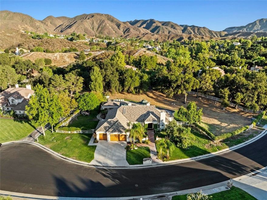 Stunning single-story home on a quiet cul-de-sac in the sought-after Crystal Springs Ranch area of Sand Canyon. Set on nearly an acre, this private estate blends elegance with resort-style living. Inside, you’ll find 3 bedrooms plus a den/office that can easily serve as a 4th bedroom, 3 full baths, and thoughtful spaces throughout. The gourmet kitchen features stainless steel appliances, double ovens, a large island, hammered copper sink, bronze fixtures, and a charming breakfast alcove with custom cabinetry. Between two of the secondary bedrooms is a versatile flex space, perfect for study, play, or a lounge area, and these bedrooms share a Jack and Jill bathroom. The optional 4th bedroom is also connected to a bathroom, adding functionality for guests or multi-generational living. The interiors include soaring ceilings, wood floors, French doors, and three fireplaces, with a primary suite retreat showcasing a spa-like bath with custom cabinetry, elegant vanities, a handcrafted hammered copper soaking tub, glass block walls, and a hidden walk-in closet. Outdoors, the property transforms into an entertainer’s paradise with a sparkling pool and spa, a full outdoor kitchen and barbecue area, gazebo, and a covered patio that spans nearly the length of the home. With its three-car garage, indoor laundry, and RV potential, this home is as functional as it is beautiful, offering the perfect balance of luxury, privacy, and the Sand Canyon lifestyle.