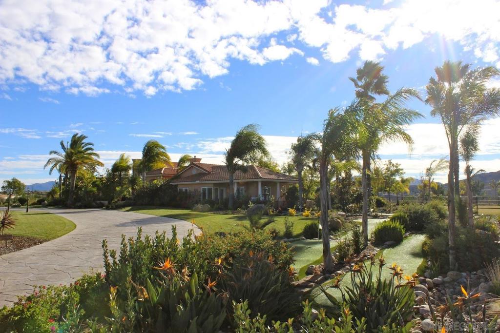 Welcome home to one of the most amazing properties in San Diego County! Rarely will you find a property with this many world-class amenities! Do you like to play tennis? Choose between your own private hard court or grass court. So, is pickleball your game? Invite a bunch of your friends over to play on your two championship courts separated by a beautiful two-story viewing deck. How about a little mini golf to unwind at the end of the day? Grab a club and test your skills on your own custom 9-hole course.... and that's just the beginning! There is shuffleboard, outdoor chess, hammocks, a fire pit, multiple water features, pizza oven and multiple gathering areas! The home includes a serene living room looking out to the pool, a large family room perfect for entertaining and family game night, a beautiful dining room that shares a fireplace with the living room, a spacious kitchen with a walk-in pantry, and a spiral staircase that leads to a reading nook or home office and has the most amazing views of the surrounding hills. The master retreat is elegantly designed with a fireplace, large windows, a sitting room, and a well-appointed master bath and walk-in closet. There are 3 bedrooms, each with their own bathroom en suite, and an additional optional bedroom with a bathroom en suite and a sliding glass door out to the back patio. The property also includes two 50-amp RV hookups and a clean-out station, a "safari"-style tent, 2 water wells, and room for horses. It's just too much to list! Schedule a visit and plan on spending some quality time taking it all in.