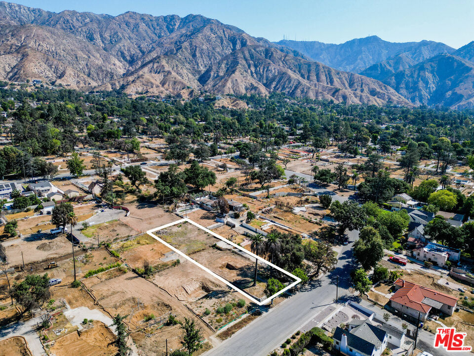 If you want to be a part of rebuilding Altadena this 17,223 sq/ft flat lot, with incredible views of the mountains, is a wonderful opportunity. A beautiful large craftsman home with 4 bedrooms and two bathrooms sat beautifully on this raised front yard behind a river rock wall. Two giant canary palms and a large oak tree, which all survived the Eaton Canyon fire, shade the front yard. The backyard is large enough for a guest house, mature fruit trees, a pool, and an outdoor kitchen/entertaining area. The driveway, which extended to the garage, is still in place. Phase 1 and 2 debris removal are complete and a survey was done post cleanup.
