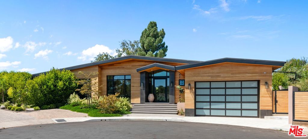 A brand-new single-story masterpiece, perfectly situated on a quiet cul-de-sac just north of the prestigious Trousdale Estates. Surrounded by beautiful trees and serene canyon views, this contemporary residence offers an exceptional blend of luxury, comfort, and sophistication. Designed with a seamless open floor plan and effortless indoor-outdoor flow, the living room boasts floor-to-ceiling automated sliding glass doors that open to a private backyard oasis with an infinity pool, spa, and waterfall. The expansive great room unites the living, dining, and chef's kitchen, featuring Miele appliances, dual sinks and ovens, two dishwashers, built-in espresso/coffee maker, microwave, and a refrigerator and freezer. A generous island and elegant European wood floors enhance the home's refined design. Offering 6 ensuite bedrooms and 9 bathrooms, the home provides unparalleled comfort for both family and guests. The media room, complete with a wide electric fireplace can be closed for privacy or opened to the main living area. The grand primary suite is a sanctuary, featuring a cozy seating area, private patio, and a stunning pearl onyx double-sided fireplace. It is complemented by two luxurious bathrooms with a soaking tub and steam shower complete this extraordinary retreat. Additional highlights include a temperature-controlled glass wine room, Sonos Arc sound system, and the finest finishes throughout. A true entertainer's dream, this residence exemplifies modern luxury at its finest.