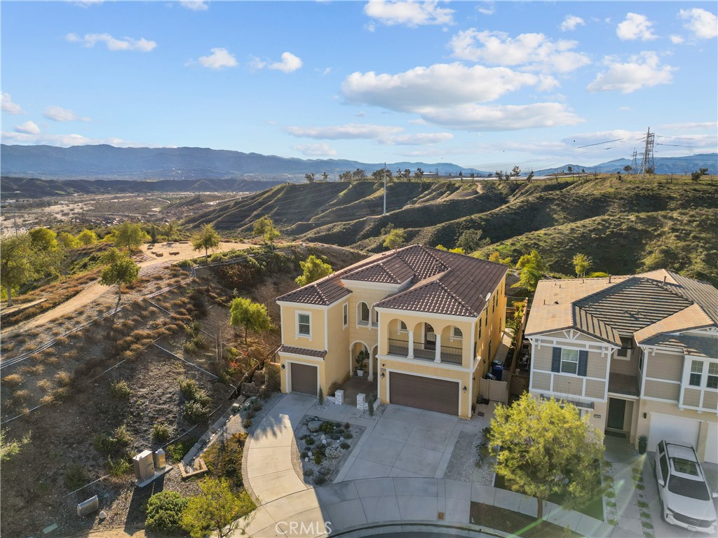 Welcome to The Heights — a prestigious gated enclave within the sought-after Five Knolls community. This stunning nearly 4,000 sq. ft. residence offers 6 bedrooms and 6 bathrooms, thoughtfully designed to combine luxury, comfort, and functionality. A grand foyer warmly welcomes you inside. On the main level, you'll find a guest bedroom with its own private ensuite, as well as a stylish powder room. The heart of the home is the chef’s kitchen, complete with abundant cabinetry, a walk-in pantry, and expansive countertops ideal for both everyday prep and elegant entertaining. The kitchen seamlessly opens to a spacious dining area and an oversized living room with sliding glass doors that lead to a covered patio — perfect for indoor-outdoor gatherings. Upstairs, every bedroom includes an en-suite bathroom for ultimate privacy. The laundry room features extensive wraparound counters and custom cabinetry for optimal convenience. One of the standout upstairs spaces is a private suite, offering two adjoining rooms, a full bath, a phenomenal walk-in closet, and its own balcony — ideal for guests, extended family, or a luxurious home office setup. The primary suite is a true sanctuary, showcasing spectacular sunset views and a dramatic entry that leads into a spacious retreat. The spa-inspired bath includes dual vanities, an oversized soaking tub, a massive double walk-in shower, and two large walk-in closets. Situated at the end of a cul-de-sac, this home boasts a generous driveway leading to two separate garages, ensuring ample parking and storage. A large side yard offers the perfect space for a dog run, garden, or private play area. Just a short stroll along scenic paseos brings you to The Club at Five Knolls, featuring a pool, spa, outdoor kitchen, playground, and more. Nearby Golden Valley Park offers additional amenities, including a dog park, expansive greenbelt, sports courts, restrooms, and an inclusive playground. This is a rare opportunity to own a truly exceptional home in one of the most desirable neighborhoods in the area. Come experience The Heights lifestyle.