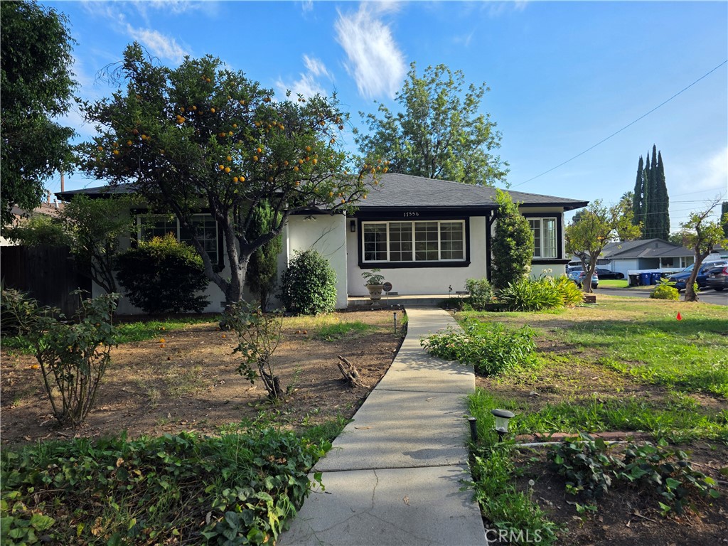 Welcome to this beautiful corner lot home located in the City of Granada Hills! Freshly painted inside and outside and with fruit trees adorning the front yard. INCLUSIONS: New Light Fixtures, Refrigerator, Gas Range , Microwave, Washer, Dryer and New Dishwasher. As you enter the front door to the foyer there is a hall closet. Enter the large living and dining area, with a chandelier in the dining room. Kitchen is off the dining room with lots of cabinet space. Primary bedroom which is off the living room has an ensuite bathroom, fireplace, built-in bookcases, closet, and access to the outside patio. 2 other bedrooms have wood flooring and lots of light. Hallway bathroom has a separate tub and shower. Off the kitchen there is a laundry room, with access to both the back patio and the large garage. Outside you will find a large patio, partially covered, and a yard with a lot of trees. Granada Hills is BEST known for its school district. Located within the boundaries of the award-winning Granada Hills Charter High School and minutes away from Granada Village — this home truly has it all. Don’t miss the chance to make it yours! this home offers not just comfort but an unbeatable location.