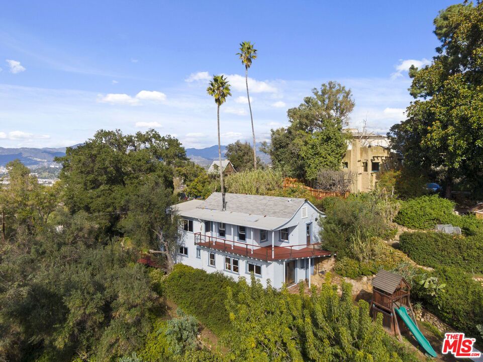 Experience an authentic countryside lifestyle in the heart of Echo Park within an historic landmark property. Perched atop Elysian Heights, this charming country style bungalow home is situated on a rural 4-acre property adjacent to 600+ acre Elysian Park and is part of the Atwater Bungalows designated as Historic-Cultural landmark by the City of Los Angeles under the number HCM #1241. This two-story property offers a one-of-a-kind experience of bucolic charm, retro-chic beauty blended with the comforts of modern living. The first floor starts with a warm foyer, a pastoral kitchen equipped with a dishwasher, a brushed copper countertop and hood, a farmhouse sink, and a gas range. Appreciate the serenity of the living room with the wide view of the hillside in front of a cozy wood stove. Two bedrooms and a bathroom complete the features of the top floor. Once you go down the staircase, you will have to choose between two very large bedroom, one could be used as an entertainment room as it displays a bar and a wine cellar hidden within the floor to preserve wine temperature. A spacious beautiful recently renovated bathroom with stylistically tiled shower separates the bedrooms. A laundry area with washer and dryer is also part of the ensemble. An abundance of light, greenery, hillside and ocean views pour into the multiple windows of these rooms, effortlessly blending the incredible luxurious outside scenery within the charm of the chic farm-style interior. The home offers incredible outdoor attributes to entertain family and guests with wrap-around decks, two patios and two gardens, a swing and a slide for the children perfect to set outdoor dinner or enjoy glass of wine while contemplating the sunset. A warm original preserved hardwood floor enhances the authenticity of this unique experience. Another bonus of this house is the roomy attic converted into a loft that could be the perfect place for a game room or office. Close to all the restaurants and cafes that Echo Park offers, this historic bungalow exemplifies the country lifestyle within the big city.