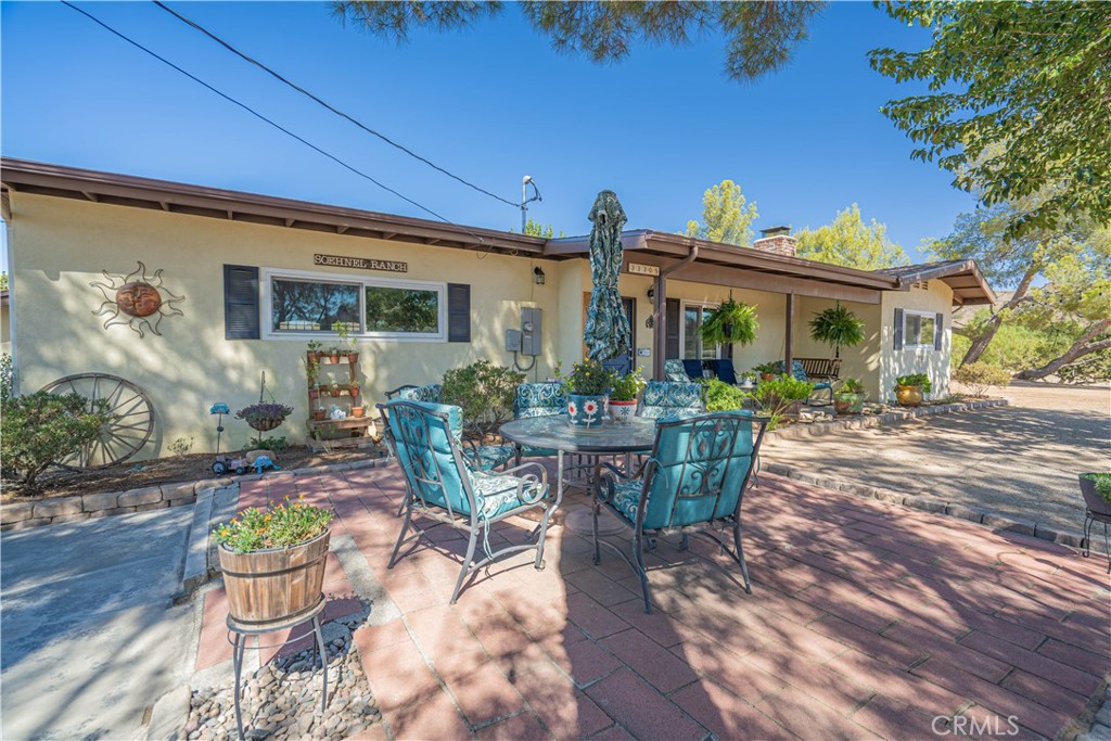 Adorable mid-century equestrian cottage and great starter home in the heart of Agua Dulce! This inviting 2 bedroom, 2 full bathroom property sits on a spacious 2.5-acre fully fenced and cross-fenced lot with equestrian amenities and plenty of room to grow. A cozy covered front porch welcomes you inside, where the home showcases pine tongue-and-groove ceilings, pine kitchen cabinetry, and a real brick fireplace for warmth and charm. Recent updates include updated windows and stucco, an insulated garage door, newer water heater, upgraded 200-amp electrical panel with generator hookup, and Silicot-lined water storage tank, a Aquasana whole-house filtration plus under-sink filter. The separate side yard features a refinished pebble-tech pool and spa, fully fenced, with an updated variable-speed pump, while the private backyard offers a covered patio and a split rail fenced lawn with a beautiful view of Saddleback Mountain. The property is well-equipped for horses and rural living with approximately ½-acre pasture, 40-ft round pen, electric fencing, covered stall with feeder trough, covered hay storage, and a chicken coop. Additional structures include a 23' x 25' outbuilding/garage with insulated office and heat/AC, a newer 8x8 storage shed, and RV hookups with power, water, and dump station. All of this is just moments from the Agua Dulce market, restaurants, coffee shop, and hardware store, offering small-town charm with everyday conveniences close by.