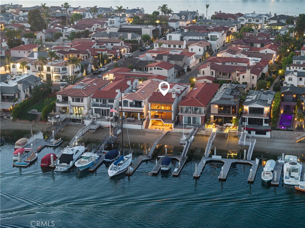 Sited on the Harbor, near the eastern end of coveted Lido Isle, 809 Via Lido Soud offers a spectacular and rare bay front appointment with its own private dock. Offering panoramic vistas of one of the broadest and most dynamic channels in the harbor, the home offers a spectacular perspective with year round sunset views. Spanning over 4300sf over three levels (one below grade), this home is one of the largest homes of any 30ft lots on the island. The entry level offers abundant space and light and features a substantial office with doors to the outside, the kitchen with water views, a full bath and a powder room, a separate laundry room, and a dining room which opens to a large family room that features two story ceilings with windows out to the harbor that span the width of the home and are over 17 feet in height. Downstairs (below grade) offers a bedroom, a full bath, a substantial storage room, and a large game room with wet bar which opens out to the dock and a private covered patio at the water's edge. Upstairs offers three ensuite bedrooms, including the primary with beautiful water views which is in a loft configuration with doors that can be closed for privacy. Homes near the end of the island are coveted and 809 Via Lido Soud offers superlative characteristics that rarely come available. Beyond the walls of the home, Lido Isle offers its residents an exclusive lifestyle and amenities including: a private beach, clubhouse, yacht club, tennis and pickleball courts, multiple parks, and an amazing community. A short walk or golf cart ride brings you to the beach, and Lido Marina Village, with its upscale shopping and dining. This is a rare opportunity to own a generational property in one of the best locations in the world.