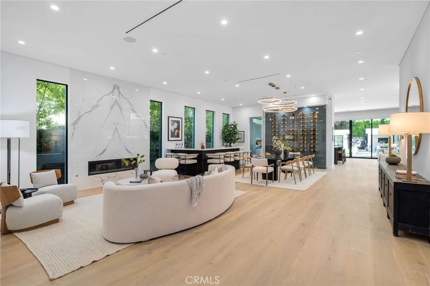 Recently refreshed, this Sherman Oaks home seamlessly blends sleek design with inviting warmth. Inside, you’ll notice the details—wide-plank white-oak floors with natural texture, porcelain-wrapped fireplaces, dual kitchen islands, and intuitive home technology for effortless living. Glass pocket doors open to a private backyard retreat with a heated zero-edge pool, spa, cabana lounge, a bonus room ideal for a gym, studio, or creative space, and a sleek firepit—perfect for golden hour gatherings. Upstairs, the primary suite offers a private terrace, boutique-style closet, and a spa-inspired bath wrapped in large-format porcelain tile. Each of the five additional ensuite bedrooms provides comfort and privacy. A custom-tiered home theater, integrated automation, and an EV-ready garage complete this beautifully turnkey modern. Privately nestled in a quiet enclave just minutes from Ventura Blvd and the heart of Sherman Oaks, this home blends timeless design with the ease of modern living—where every detail feels just right.