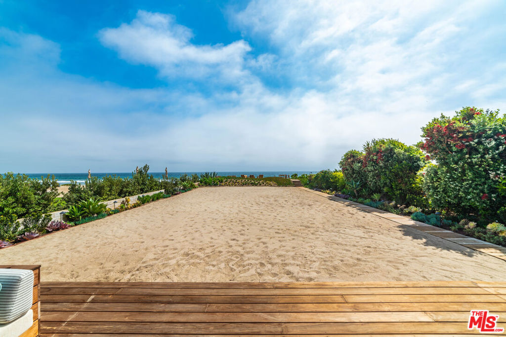 Available now! This dreamy Broad Beach oceanfront estate invites you to live and entertain indoors, outdoors, or both. Large rooms, vanishing walls, expansive decks, and even a private beach provide a stunning panorama of ocean and islands. The open layout offers spectacular sightlines and an ideal atmosphere for sophisticated entertaining and relaxed beachfront living. Every room is complete with gorgeous furnishings and fixtures, wonderful natural light, and beautiful detailing. The living room is huge, with high, plank-and-beam ceilings, fireplace, and stone floors, plus a wall of glass at one end that opens onto an enormous wood deck. Adjacent to the living room, the dining/billiards room features a remarkable convertible table for billiards, ping pong, and dining. The kitchen will inspire any chef, with its glorious views, generous built-ins, quality appliances, center island, bar seating, beverage cooler, and large pantry. Also on the main floor is a very comfortable home theater, a laundry room, and two en-suite bedrooms, one with four built-in bunks complete with lighting and ladders. Upstairs, there are more bedrooms, one currently used as a gym, plus the breathtaking primary suite. This serene retreat sits beneath high, sloped ceilings, and has a wall of glass opening onto a private ocean-view balcony. Dividing the room is a double-sided fireplace, with the sleeping area on one side and spacious sitting room on the other. This sublime space has dual walk-in closets and a lovely, spa-style bath. The home's impressive oceanfront backyard features an outdoor kitchen complete with barbecue and pizza oven, an enormous dining table, a sitting area, a lounge with firepit and built-in seating. Beyond the deck is a large private sandy beach, perfect for volleyball or parties, plus another sandy refuge with room for dining and relaxing, and a path across the riprap to the sandy expanse of Broad Beach. The outdoor area has built-in heat lamps and lighting, sprinklers, and an outdoor shower. In addition to numerous smart-home features, the home has a three-car garage with an extra refrigerator and freezer, plus guest parking for five cars. As a summer getaway or a year-round sanctuary, this Malibu residence is immaculate, inviting, and full of refined beauty. Pursuant to California AB 2202, any guest cleaning responsibilities and related charges are transparently outlined in the rental contract provided upon booking.