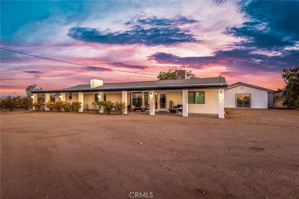 Welcome to your dream desert escape in the highly desirable Yucca Mesa neighborhood of Yucca Valley. This fully remodeled 3-bedroom, 3-bathroom home sits on a sprawling over 5 acres, offering space, privacy, and endless potential. This home features all-new everything; roof, electric HVAC, dual-pane windows, interior and exterior paint, luxury vinyl plank flooring, carpet in bedrooms, doors, and a brand-new septic and leech line system installed less than a year ago. Inside, you’ll find a bright, open layout with beautifully upgraded finishes throughout. The kitchen and baths are fully renovated with new cabinets, countertops, modern sinks, and stunning walk-in showers with glass enclosures and herringbone tile. The spacious primary suite offers a spa-like retreat with a rain shower head and serene desert views. Two sleek electric fireplaces add warmth and modern charm to the living areas. Outside, a massive detached 4-car garage includes an additional 1,060 sq ft of flexible space perfect for a home gym, workshop, or future conversion plus a full-length attic for hidden storage and a 50-amp RV hookup for added convenience. Multiple covered patios invite you to unwind and enjoy the quiet, star-filled nights with no light pollution. Whether you're looking to create a personal retreat, horse property, or simply enjoy wide open skies and peaceful living, this property delivers. Don’t miss the opportunity to own this one-of-a-kind desert gem with room to grow and explore all just minutes from Yucca Valleys amenities, Joshua Tree National Park, and more.