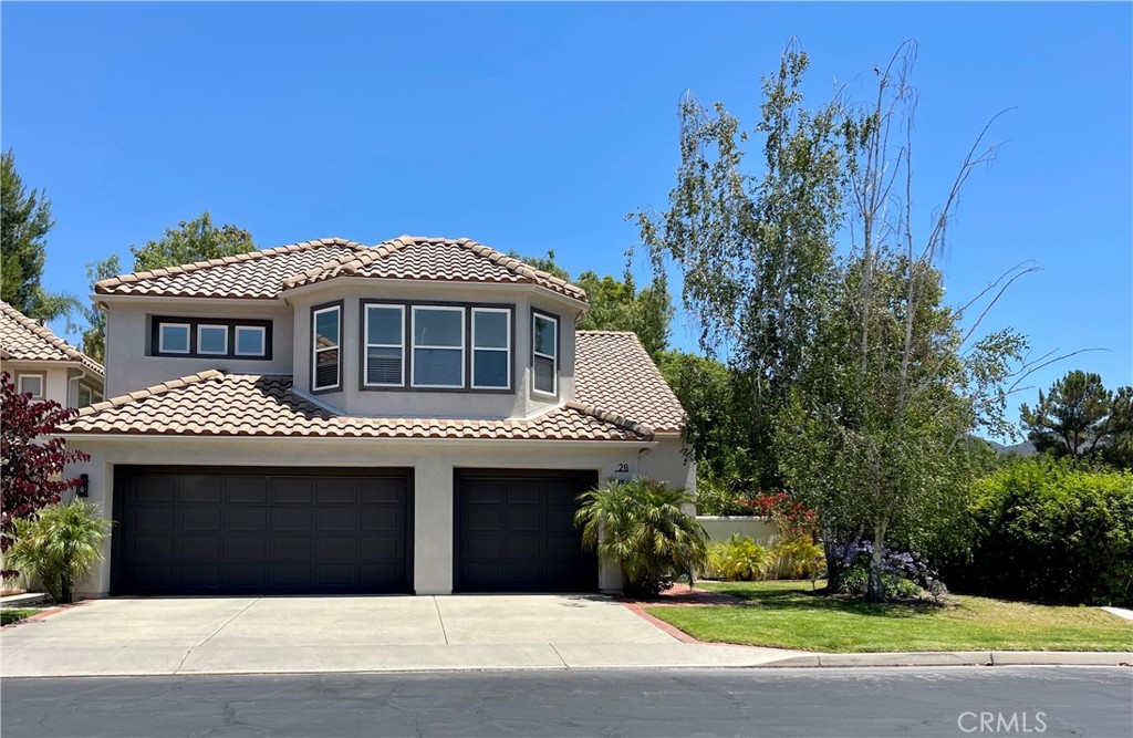Enjoy all that prestigious Dove Canyon has to offer at 28 Lawnridge, a beautiful modern residence perched on a corner lot near the top of this coveted gated golf community in the foothills of Trabuco Canyon. This popular 4-bedroom floorplan (3 bedrooms and a large bonus room) has abundant natural light, an open layout, and is beautifully updated with luxurious surfaces and a modern neutral palette. As you enter, you'll find cathedral ceilings, elegant laminate flooring, an inviting living room, a dining room and family room with fireplace, guest bath and spacious laundry room. The kitchen has been tastefully remodeled with quartz countertops & custom tile backsplash, center island with a statement light fixture, stainless appliances, gas cooktop, wall oven and built-in microwave. Upstairs, a luxe primary suite awaits you with cathedral ceilings, ensuite bath with dual sinks, separate shower and soaking tub, and walk-in closet. Two large secondary bedrooms, an additional full bath, linen storage and an oversized bonus room complete the second floor layout. The entertainer's rear yard is ideal for year-round outdoor living, with a patio, firepit, low maintenance turf area, trees and more. An energy-saving whole house fan eases your energy usage, and the garage is equipped with a 240-volt Tesla charger that is compatible with all electric car models. The world-class amenities of Dove Canyon will be yours, with tennis, pickleball, a resort-style pool complex, 24-hour security and guarded gate, plus a variety of golf and social memberships available for the Dove Canyon golf club. Welcome home!