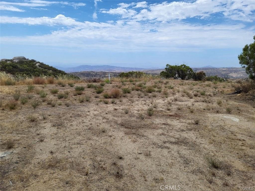 Gorgeous panaromic view parcel located near the end of a secluded cul-de-sac within the private gated community of Lake Riverside Estates. Nearly 3 acres of gentle rolling terrain bordering 121 acres of conservation land. A cleared driveway leads to two separate graded pads to build your own private estate home. This beautiful lot is graced by large manzanite trees and several groupings of large boulders. Electricity is at the property corner. Escape from the city to clean air and brilliant night skies. Lake Riverside Estates is a unique equestrian community that includes such amenities as a community pool and playground with picnic area, private airstrip, fire department, equestrian arena, riding trails and 55 acre lake with dock for fishing, kayaking and other recreational uses. Lot has a capped well installed by previous owner that is 550' deep.