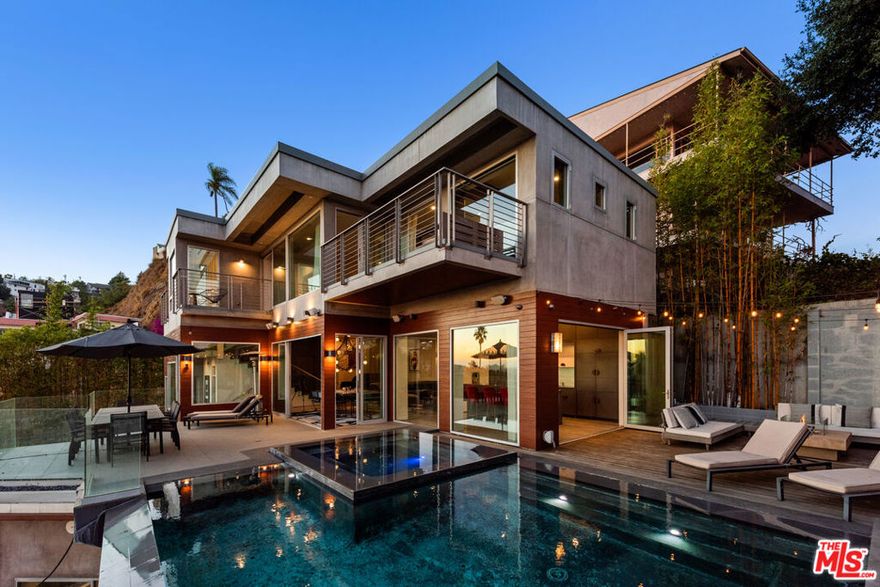 A Hollywood Hills Masterpiece with Unrivaled Views and Unmatched Luxury. Designed by Irving Philips, this architectural gem is perched on a private cul-de-sac above the iconic Chateau Marmont, offering sweeping vistas from Downtown LA to the Pacific Ocean. Seamlessly blending modern design with the natural beauty of its surroundings, this residence epitomizes California indoor-outdoor living with retractable doors, expansive terraces, and a stunning infinity-edge pool, where stunningsunsets are yours every evening from arguably the best seat in the Hills.The main level features an open-concept layout, ideal for entertaining, with a sleek outdoor kitchen,meticulously landscaped grounds, and a waterfall focal point. Upstairs, the luxurious primary suite occupies the entire top floor, complete with a captivating private balcony,spa-like bathroom, and panoramic views that redefine tranquility. Two additional en-suite bedrooms provide privacy and comfort for family or guests. State-of-the-art amenities include an iPad-controlled Smart Home system, Nest climate control, and comprehensive security. Designed for relaxation and entertainment, this property embodies Hollywood Hills glamour with every conceivable amenity at your fingertips.