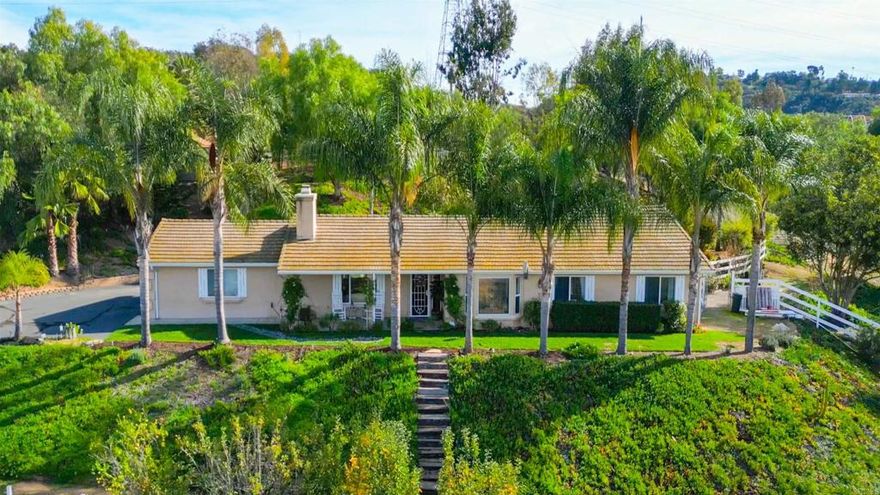 Welcome to Heritage Park Estates - an enclave of 13 custom built homes in Valley Center just minutes from the 15 freeway. This single story home sits on 2 acres and is located at the end of a cul-de-sac with beautiful mountain views. The home offers just over 1900 sq ft of comfortable living space and features 3 bedrooms plus a den, 2 full bathrooms, a living room, kitchen, and separate dining room. The living room offers vaulted ceilings and a cozy, stacked-stone fireplace. The spacious den makes the perfect office, library, craft room, or could be converted into a 4th bedroom. The primary bedroom features an oversized ensuite bathroom with double door entry, walk-in shower, soaking tub, a vanity with dual sinks, and a walk-in closet. The 3 tiered lot offers flexibility and creativity for usage. The main yard surrounding the house feels private and serene with a large covered back patio, multiple raised garden beds framed for year-round use, approx 26 fruit trees including tangerine, Valencia orange, navel orange, apple, lemon, plum, peach, apricot, lime, tangelo, and mulberry. There is also a 5 barrel rain collection system to help save on water bills. There are steps up to the top tier which currently has an above ground pool but is also a perfect spot for an ADU. The lower level is fully fenced and has a gravel driveway for parking an RV or additional vehicles. The lower section also contains an open space easement. The home has 24 solar panels with a low monthly payment of $159/mo with only 10 years left on a 20 year lease. There are also 2 sheds on the property ideal for extra storage. All this and no HOA! If peace and quiet and beautiful views are what you are looking, while still being close to everything, 11106 Calgary Way is the perfect address to call home!