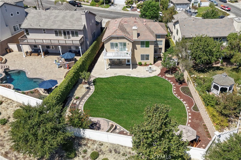 Welcome to this beautiful 4 bedroom, 3 bathroom home offering almost 2400 square feet of comfortable living space on a generous 9,338 square foot lot. Step inside to soaring vaulted ceilings in the formal living room, a formal dining area, and an open kitchen that flows seamlessly into the family room with serene hillside and backyard views. This lovely home is perfect for families or multi-generational living, featuring a convenient downstairs bedroom and bathroom with walk in shower, ideal for guests or in-laws, and the oversized 2 car garage lends opportunity for the potential of a separate entrance to the downstairs bedroom. You'll also enjoy the inside laundry room located on the main floor. Upstairs, the spacious primary suite offers a private retreat area, and a balcony overlooking the hills, perfect for unwinding at the end of the day, along with a relaxing jetted tub and walk in shower and dual vanities. Two additional bedrooms share a Jack-and-Jill bathroom with dual vanities, tub and shower, offering both privacy and convenience. The oversized backyard is a true standout, featuring sweeping hillside views and endless possibilities—entertain, garden, or even add a pool. Additional highlights include a whole-house fan to help keep your home cool and a pull down attic/storange area located in the garage. With abundant natural light, flexible living spaces, and incredible outdoor potential, this home blends comfort, functionality, and opportunity. Don’t miss your opportunity to make it your own!