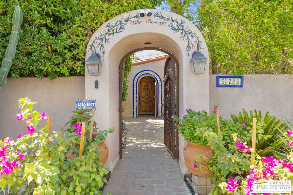 Truly UNIQUE, this tucked-away Spanish-style retreat captures the MAGIC of Palm Springs living! Located in the Warm Sands neighborhood, just minutes from downtown, this home is gated and private with fantastic curb appeal, surrounded by fountains and lush landscaping. OWNED SOLAR is another plus! Tall, vaulted, wood-beamed ceilings are a theme and the main living area opens through dual sets of French doors to patios and an oversized spa/pool (spool), perfect for relaxing year-round. The living room features an adobe style fireplace and a wet bar with beverage fridge. The beautiful kitchen is equipped with Viking appliances and solid wood cabinetry, while Venetian plaster walls and bullnose corners add timeless character throughout. The primary suite includes solar tube lighting and a glass-block accented walk-in shower. A guest suite with ensuite bath opens to a private patio framed by mountain views and mature plumeria trees. A built-in Murphy bed offers extra flexibility for hosting. Outdoors, the large spool accommodates up to ten, ideal for cooling off in summer or warming up in winter. Two exterior sheds provide plenty of storage, while gated parking allows space for two cars. This is truly a rare opportunity in one of Palm Springs' most historic and convenient neighborhoods. Eligible for the city's SHORT-TERM RENTAL permit as well! Take the Matterport Virtual Tour for a better sense of flow.
