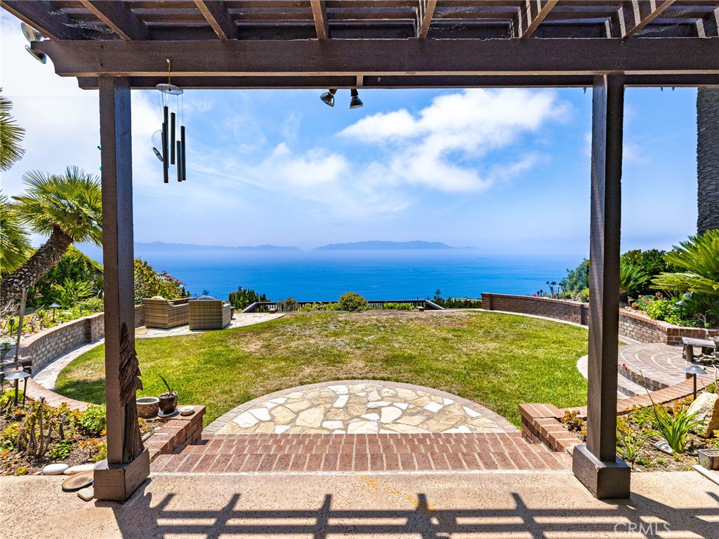 Welcome to this exquisite residence residing in Palos Verdes with sublime Pacific Ocean views touched by outstanding Peninsulas. Double-door entrance swings open to massively vaulted ceilings that welcome you to a vibrant front foyer with large seating. The house rises up to a formal dining area that glides into the gourmet kitchen that is enveloped with views. Thermador appliances complement the incased wood refrigerator and vent systems that completely blend with the surrounding cabinetry.
The desirable wood accents continue into the flooring that lead to custom Pella doors that exhibit one of the best views the county of angels offers. Breathe taking picturesque oceanic views that completely encompass our little island, Mira Catalina. The yard is hugged by smooth stucco, Palos Verdes stone, custom BBQ, finished planters, and continued space for roaming in the grassy knoll, all while basking in the blue hues. The terrain transcends towards a wonderful deck, that finishes this experience. Jetting out off of the cliff and into the surrounding hillside is something to remember, being one of the only homes with this asset. Capturing pleasant up-drafts of atmospheric wind, world renown golf courses, Terranea resorts, immaculate Peninsulas, and cascading ocean air. 3-car garage. Sought-after award winning Palos Verdes Peninsula school systems are all welcomed to be enjoyed.