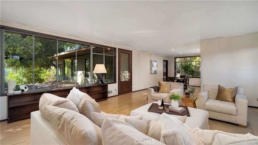 Welcome to 1895 N. Arroyo Blvd, a charming single-level mid-century modern home set on over 15,000 square feet of private grounds in one of Pasadena’s most desirable tree-lined neighborhoods, just minutes from the Rose Bowl. Designed for comfort and effortless California living, this 1,912 square foot residence blends timeless architecture with modern upgrades. The inviting living room features original oak hardwood floors, expansive windows that fill the space with natural light, and a fireplace that anchors the room with warmth and character. Off the living room, a private front courtyard provides a peaceful setting for morning coffee or evening relaxation. At the heart of the home, the updated kitchen showcases stone countertops, a waterfall island, custom soft-closing cabinetry and drawers, and built-in high-end appliances, offering the perfect balance of style and functionality. The open layout creates an easy flow between the kitchen, dining, and living spaces ideal for everyday living and entertaining alike. The primary suite is a serene retreat with multiple closets, a comfortable sitting area, an ensuite bath, and private access to the expansive backyard, where lush greenery and mature trees create a sense of privacy and calm. With no neighbors behind, the outdoor space offers endless potential for gardening, play areas, or a future pool. Additional highlights include spacious secondary bedrooms, newer HVAC, newer roof, indoor laundry, 2 car garage, large driveway, and the rare combination of privacy and proximity to Pasadena’s most iconic attractions. Located near the Rose Bowl, Brookside Golf Course, and the hiking trails of the Arroyo Seco, this home offers the perfect blend of nature, convenience, and architectural charm. 1895 N. Arroyo Blvd captures the essence of Pasadena living and ready to welcome you home.