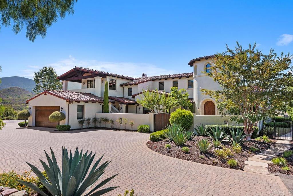 Elevated Living: Welcome to your private sanctuary in the rolling hills of Santaluz where panoramic vistas stretch for miles and luxury meets everyday ease. This custom-built estate offers a lifestyle of comfort, elegance, and connection in one of San Diego’s most sought-after- guard-gated communities. As you enter the gated motor court, you are greeted with a serene retreat that has something for everyone. This is a home where design and quality were thoughtfully curated—where daily stresses fade, laughter fills the air, and lifelong memories are made. The formal living and dining rooms provide a refined backdrop for entertaining while the chef’s kitchen - with expansive island, and walk in pantry and casual dining nook – flow seamlessly into the great room. Stacking vanishing doors connect indoor and outdoor spaces, opening to a covered loggia and fully equipped outdoor kitchen. Sport and movie enthusiasts will love the state-of-the-art home theater and adjacent entertainment lounge area and bar. The richly paneled home office, complete with built-ins and a private entrance is ideal for today’s work-from-home lifestyle. The main level primary suite is a tranquil escape, featuring a luxurious bath, an oversized walk-in closet, and a secluded patio with spa. A secondary en-suite bedroom is also located downstairs. Upstairs, three ensuite bedrooms join a guest casita with separate entrance, perfect for visitors or mulit-generational living. The backyard is an entertainer’s dream with an inviting pool and spa, sunken fire pit lounge, sport court and putting green -all offering endless fun for all ages. The four-car garage with built-in storage system provides organization for the gear and toys that accompany an active lifestyle. Your environment reflects your lifestyle and this one-of-a-kind home is paradise waiting for you.