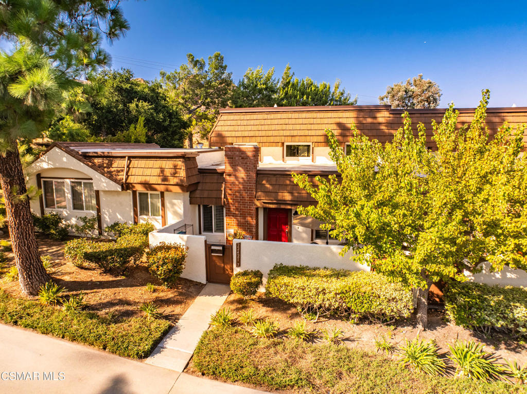 Nestled against a rocky mountain backdrop and surrounded by beautifully landscaped streets, this spacious 4-bedroom, 2.5-bath condominium is located in the highly desirable Rockpointe community of Chatsworth. Offering over 2,000 sq. ft. of living space, the home features a free-flowing layout with a living room, family room, and large dining area. The updated kitchen boasts recessed lighting, custom natural quartz countertops, a striking glass backsplash, and corner cabinets with lazy Susans. All bathrooms have been tastefully updated. Black walnut wood flooring flows throughout the downstairs and staircase, complemented by ceramic tile in the kitchen and bathrooms. The double-door primary suite entry with high ceilings provides an open air retreat. Additional highlights include scraped ceilings, dual pane windows with wood shutters, and closet organizers with built-in shelves and drawers. Two customized private patios offer inviting spaces for outdoor relaxation. The attached 2-car garage and available street parking add convenience, the location is just yards from a hiking trail which enhances the home's appeal. Community amenities include 4 pools, a clubhouse, and lush greenbelts, all near the historic Santa Susana Pass, local parks, transportation, dining, and more.