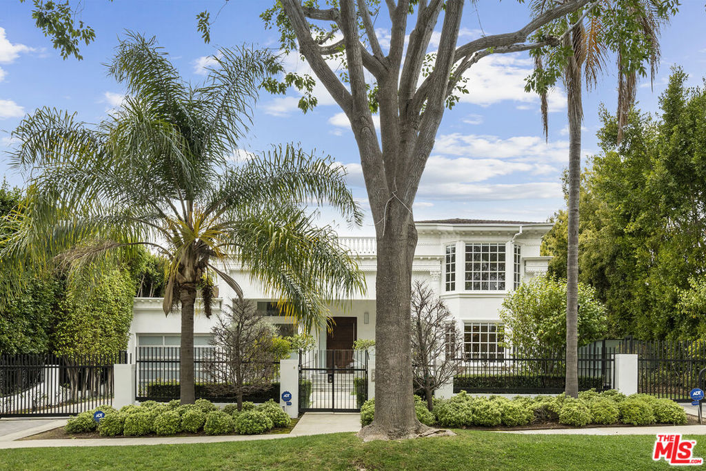 Welcome to this exquisitely updated transitional home in the prestigious Beverly Hills Flats, where timeless elegance meets modern luxury. Thoughtfully designed for both comfort and sophistication, this stunning residence boasts bright, expansive interiors and impeccable craftsmanship throughout its carefully curated floor plan. Step into the grand formal living room, where soaring two-story ceilings, gleaming marble floors, and a striking wet bar create an inviting space for refined entertaining. A generous family room provides the perfect setting for relaxation, while the chef's kitchen - equipped with top-tier appliances - flows seamlessly into a sunlit dining room framed by sunlit dining room framed by a charming bay window. The main level also features two en-suite bedrooms and a private fitness studio. Upstairs, a spacious secondary family room with a wet bar and mini fridge offers the perfect spot for movie nights, a kids' hangout area, or casual gatherings. The luxurious primary suite boasts a spa-inspired bath, massive walk-in closets, and direct access to a breathtaking outdoor deck - an idyllic retreat for morning coffee or evening unwinding. Three additional en-suite bedrooms complete the upper level, providing ample space for family and guests. Designed for effortless indoor-outdoor living, the backyard is a private oasis featuring a sparkling pool and spa, an expansive patio with an outdoor kitchen, island, fire pit, and open-air shower. A beautifully appointed pool house with a full kitchen and bath adds to the home's exceptional appeal. Located within walking distance of world-renowned Rodeo Drive, this home offers unparalleled access to the finest shopping, dining, and entertainment Beverly Hills has to offer. Experience the pinnacle of modern luxury in one of Beverly Hills' most coveted neighborhoods.