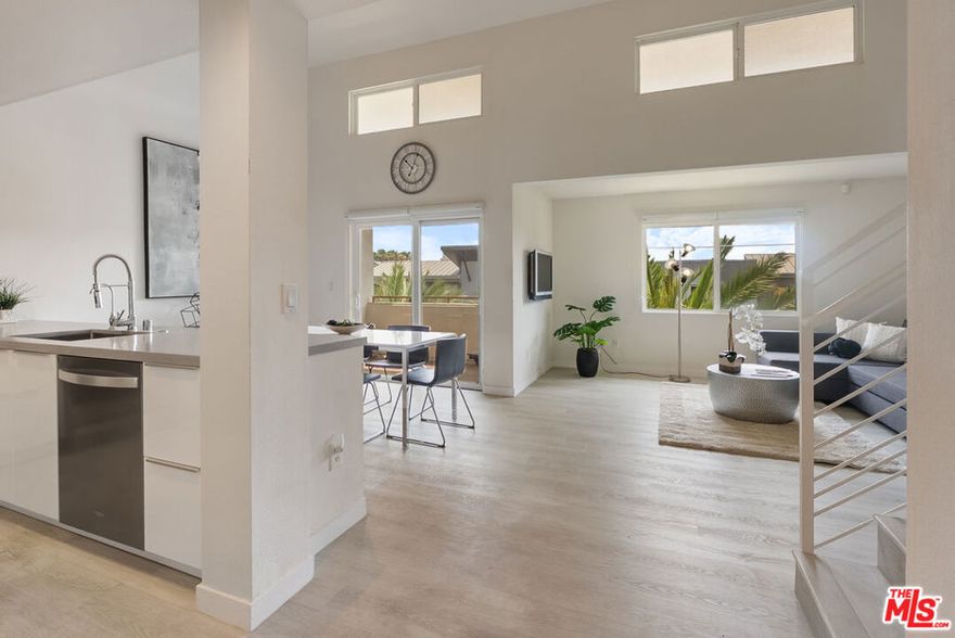 Tastefully updated top-floor penthouse loft-style condo in the heart of Playa Vista. This exterior-facing unit features a bright and open floor plan with tons of windows, soaring two-story-high ceilings, and stunning wide-plank grey flooring throughout. The light-filled living room seamlessly flows into the dining area and a modern chef's kitchen, complete with stainless steel appliances and elegant quartz countertops. Just off the dining area, step out onto a private, breezy balcony with tranquil treetop views-perfect for enjoying that coveted indoor-outdoor lifestyle. Upstairs, the airy loft-style primary suite offers a peaceful retreat with a generous full bathroom. Additional highlights include in-unit laundry, ample closet space, two dedicated parking spots, and access to a private gym exclusive to residents of the Crescent Walk building. Enjoy the best of urban living in Playa Vista-just moments from the shops at Runway, the CenterPointe Club, the Resort, and so much more!