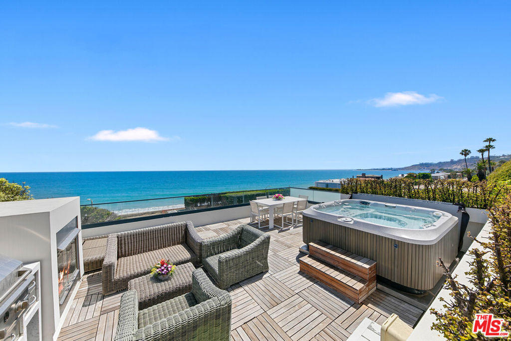 Whitewater views and spacious amenities make this townhome worth the ride on the newly opened Pacific Coast Highway. With over 3,300 square feet of luxury living, this is the perfect weekend, summer or full time beach retreat in an extremely desirable location. Immerse yourself in the Malibu coastal lifestyle in this stunning ocean view property located in the Residences at Carbon Beach and just a shell's throw from famed Billionaire's beach. Welcome to Residence #1, the premier end unit of 8 total residences with the best views and amenities. Commanding ocean views abound from all living areas, balconies and the dream rooftop terrace with built-in barbecue, refrigerator, 8-person spa and panoramic views from Santa Monica to the Malibu Pier and beyond. Infused with contemporary elegance, high ceilings and incredible light, the main floor boasts an open floor plan lending itself to both easy entertaining and gracious personal living. The cozy breakfast area leads to a dazzling chef's kitchen with marble countertops awaiting your culinary skills. The focal points of the dining area are the custom glass chandelier and the newly built wine wall. A cozy built-in office is located under the stairs. The second level features a primary suite with an ocean view spa bath and two guest en-suite bedrooms. Additional amenities include a Savant control system, automatic shades, a recently installed LED recessed lighting system and a private elevator. The gated drive through entry leads to the lower level with private dual 2-car garages for this residence and a bonus mirrored exercise room. Enjoy convenient nights out at Nobu, the Farm at the Pier, Soho House and V's, your neighborhood restaurants. The time is now to make this trophy property your residence. A touch of class awaits you.