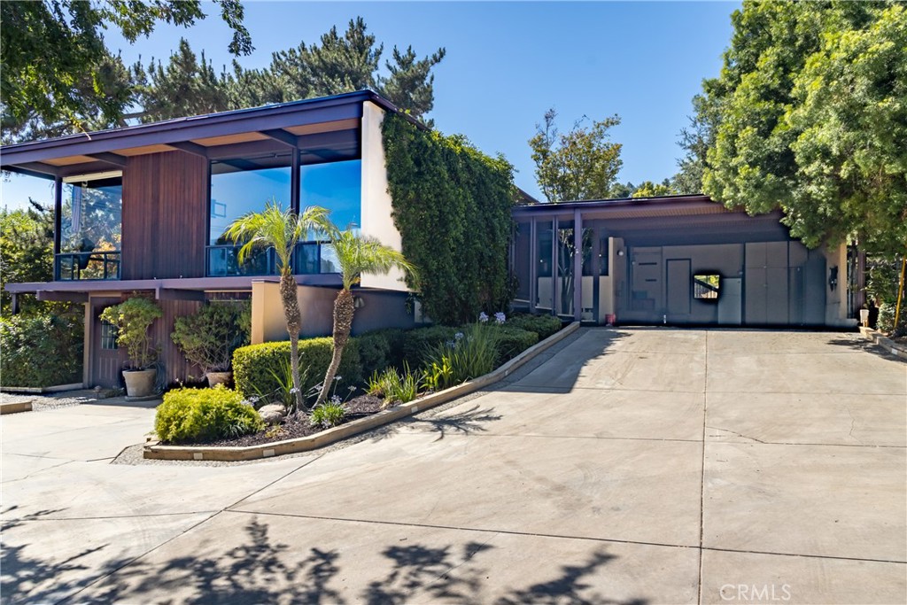 VOILA! In 1960 this spectacular Eichler style "glass house" was built by Swen Larson, a local builder for Dr. William Preston. A Eichler style home is a type of Mid-Century Modern home built primarily in California by developer Joseph Eichler between the late 1940s and mid-1960s. While not exclusively glass-walled, these homes are characterized by their extensive use of floor-to-ceiling glass and seamless indoor-outdoor connections which create an airy, light-filled atmosphere. As you drive up the long driveway to this VERY PRIVATE 1.1 ACRE LOT with MOUNTAIN VIEWS with attached carport, be prepared to soak in the unique aspect of this very custom home. The outside environment is welcomed into the interior via all the glass windows and doors! Views of the yard from every bedroom. This home definitely offers a Retreat atmosphere. Modern Kitchen with walk in pantry, double ovens and breakfast bar opens to the dining and family room with a slate wall around the large fireplace and hearth. Huge custom OFFICE WITH BUILT IN DESK, CABINETRY, and drafting table. YES! There are two Primary bedrooms with their own bathrooms! The larger primary bedroom with built in cabinetry and bathroom with glass dual sinks faces the mountain views! The second smaller primary with bath is at the other end of the home. YES! DOWNSTAIRS BONUS/GUEST SUITE/OFFICE WITH BATHROOM AND SEPARATE ENTRANCE! YES! Outdoor kitchen with built in barbecue and seating overlooking the BEAUTIFUL POOL Newly replastered plus pool plumbing & electrical replaced. YES! SOLAR OWNED. YES! NEW ROOF REPLACED IN 2025! Bring your electric car; there is an electric car charger. YES! EARTHQUAKE RETROFIT IN 2O25. Approximately 70 fruit trees on the property, to include, Avocado, oranges, grapefruit, fig. NOTE: Property qualifies as a FARM for tax purposes. YES! IT HAS 3 WATER SHARES FOR OUTDOOR IRRIGATION. This home has so many "YES" CHECKMARKS, so make your appointment to tour this home and say 'YES"!