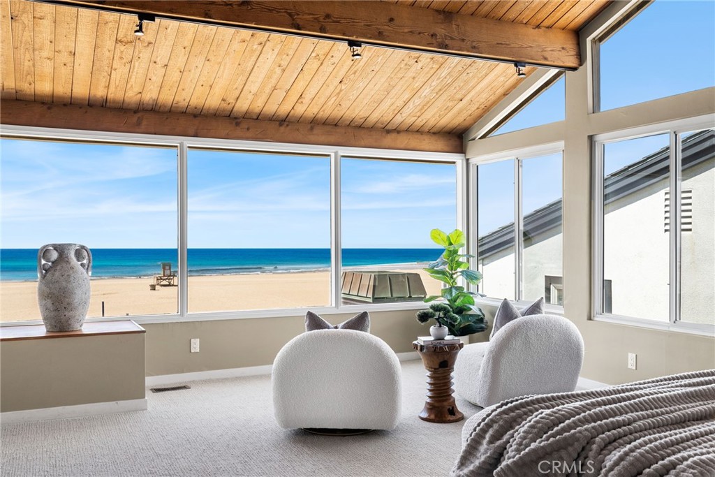 Enjoy a unique open-loft vibe at this outstanding oceanfront home in west Newport Beach, where an on-the-sand location with no boardwalk is complemented by panoramic ocean, whitewater, beach and Catalina Island views. An oversized deck opens directly to the sand and offers generous space for outdoor entertaining, barbecues with friends or simple relaxation under the sun, all with the sound of the surf as a hypnotic soundtrack. Indoors, towering open-beam wood ceilings frame a massive skylight and soar over a living and dining area that accesses the deck through three sliding-glass doors. A modern fireplace with cast concrete surround and hearth is flanked by custom built-ins, and a clerestory window allows even more natural light to illuminate the scene. A pass-through bar opens to the custom kitchen, which displays contemporary wood cabinetry with glass uppers, stone-slab countertops, an island, built-in pantry, full tile backsplash and high-end appliances. Undeniably dramatic, an open floating staircase leads to two more levels and can be seen from the living room below. Four bedrooms are joined by an office that can easily become a fifth bedroom, and three- and one-half baths showcase on-trend finishes and fixtures. Approximately 2,800 square feet, the custom residence is crowned by a third-level primary suite with stunning whitewater, ocean and sunset views. Clerestory windows, an open-beam wood ceiling, sitting area and built-in cabinetry amplify the suite’s refined style, and its bathroom shines with a skylight, floating two-sink vanity and oversized walk-in shower. A blend of wood, designer carpet and tile grace floors throughout the home, and custom lighting, an interior laundry room with cabinetry, and an attached two-car garage are featured. West Newport Beach is coveted for its casual attitude and a prime setting close to the Balboa Peninsula, Fashion Island, award-winning schools and Huntington Beach.