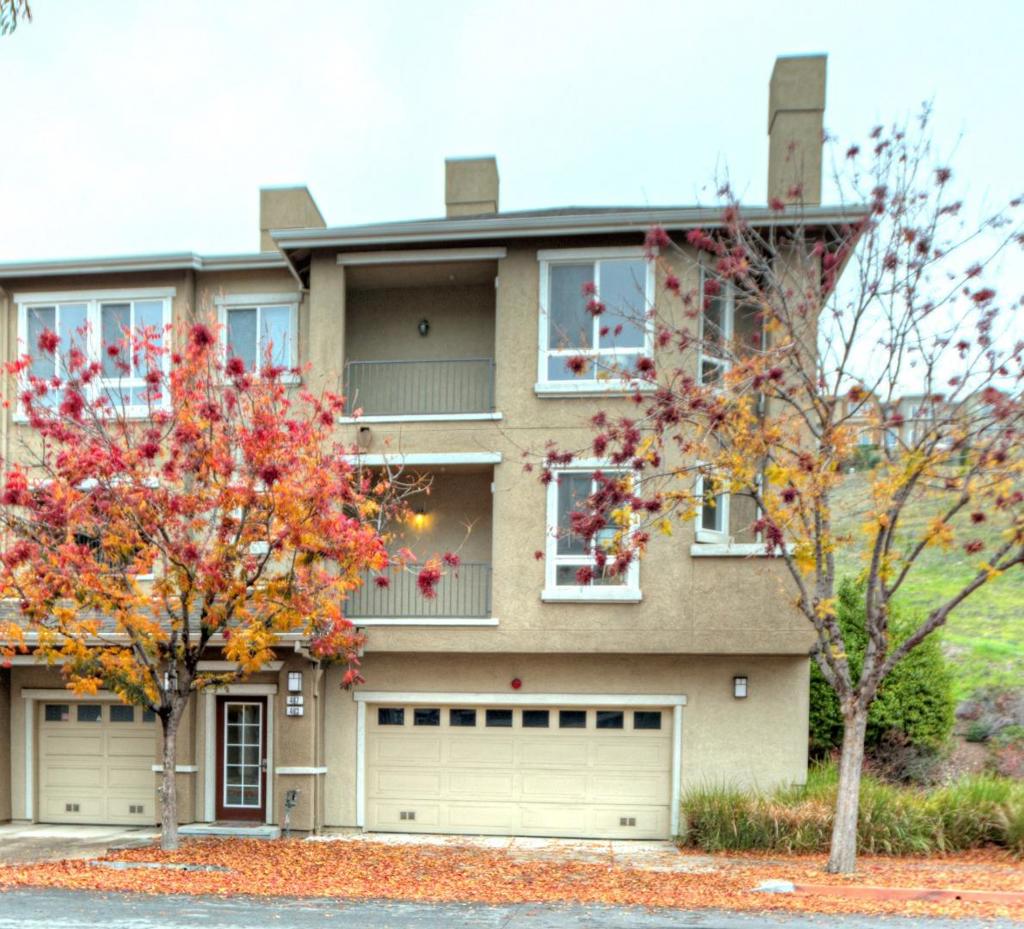 This townhome style condominium is spacious and bright, has a living room with fireplace, formal dining area, open kitchen with breakfast bar. There are beautiful hardwood floors in living areas and primary bedroom. The downstairs bedroom has a full bath and provides access to the fenced back yard. Upstairs there the two primary bedrooms with full baths and walk in closets. The laundry area is upstairs along with a good sized linen/storage cabinet. The home has been newly painted, the wood floors have been refinished and carpets cleaned. The kitchen and bathroom cabinets have new, stylish door and drawer pulls. The back and side yard and patios are very spacious with lots of room for entertaining and gardening. There is a community pool and spa. The huge 4 car garage has a large, approx 60+SF locking storage closet off the garage and a workbench. Cars are parked in tandem. Conveniently located near Hwy 87, shopping and dining.