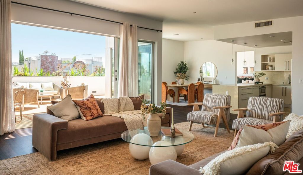 Perched on the top floor of this iconic architectural gem designed by Zoltan Pali, FAIA. This sophisticated Penthouse conveys urban elegance and the coveted California lifestyle with an open concept floor plan, soaring ceilings, sleek wood floors and expansive walls of glass that open seamlessly onto a sprawling patio. Framed by lush meticulously designed landscaping, the patio offers stunning hilltop views, perfect for both relaxation and entertaining. The chef-inspired kitchen, complete with a breakfast bar, is ideal for hosting gatherings or enjoying casual meals. Two generously sized master suites each feature their own private patios, luxurious en-suite bathrooms, and walk-in closets, providing a perfect blend of comfort and privacy. Additional amenities include side-by-side parking, a private storage room, and in-unit laundry for ultimate convenience. Located steps from Melrose Place in the vibrant heart of West Hollywood, this Penthouse is a rare opportunity to experience elevated living in LA's most desirable neighborhood.